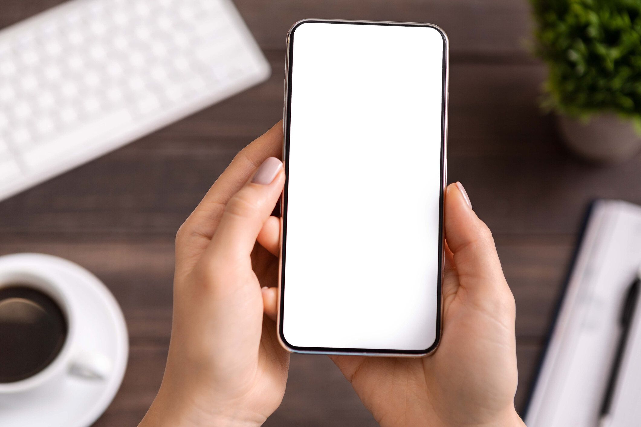 空白の白い画面で現代のスマートフォンを実証する女性