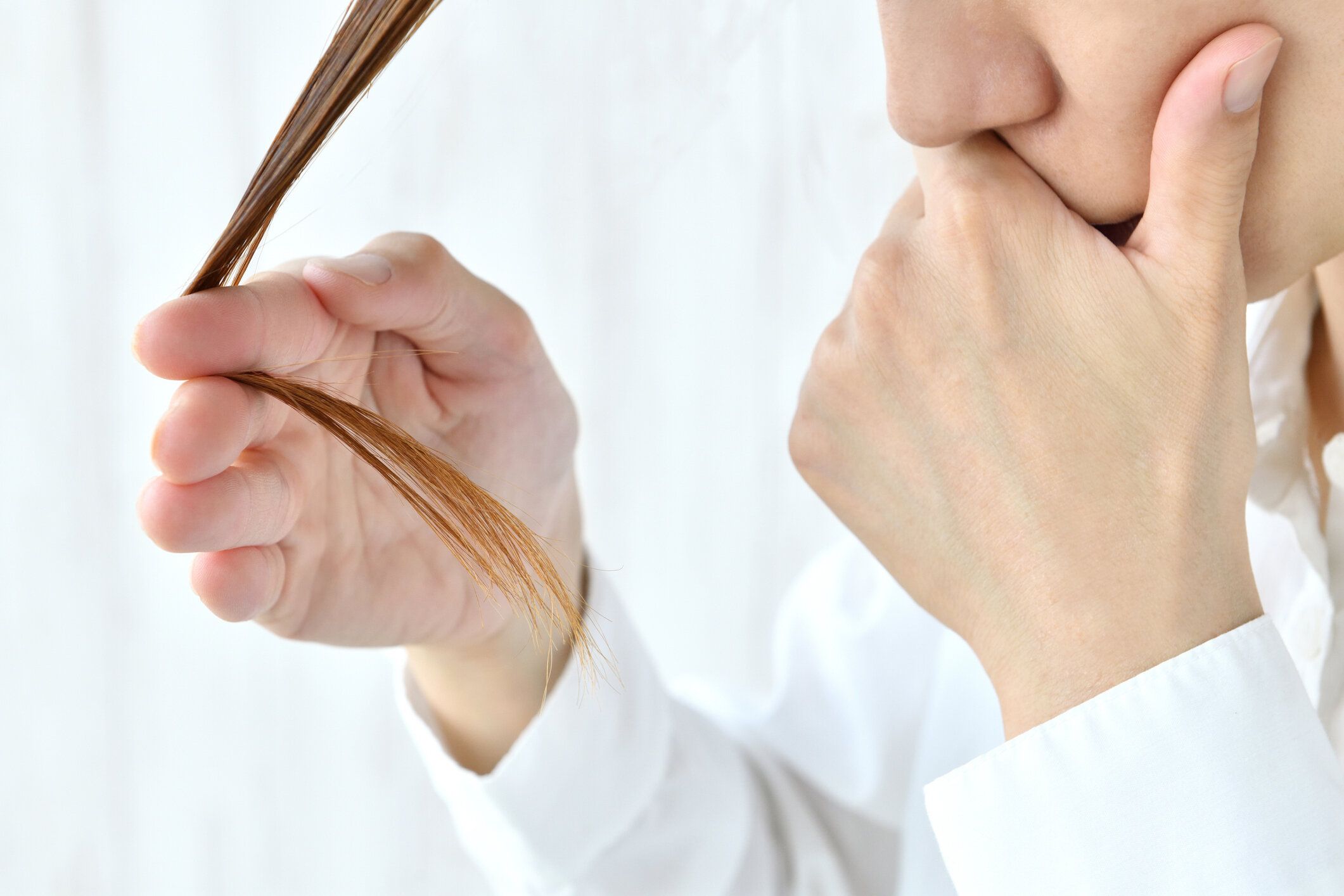 髪の状態をチェックする女性