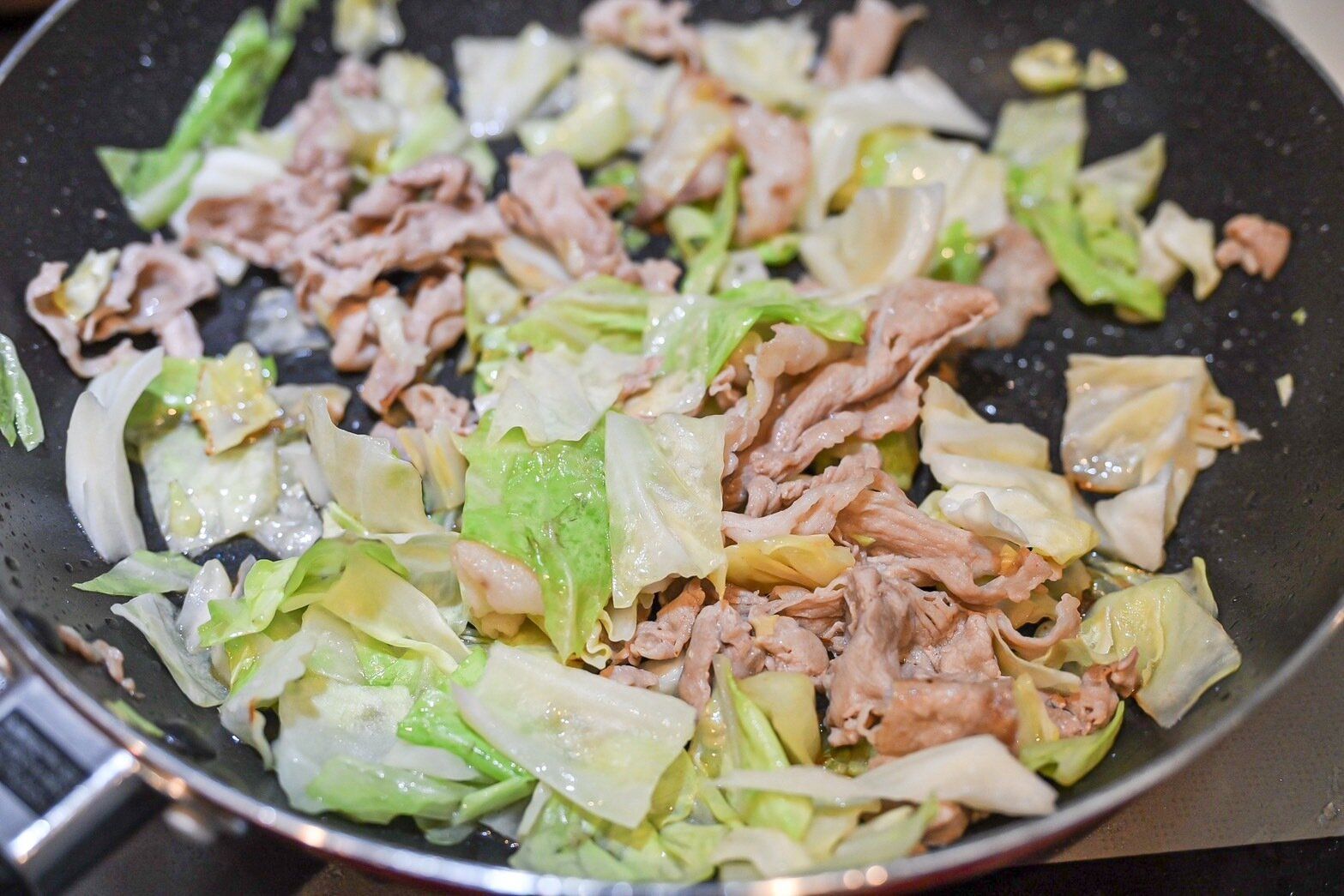 フライパンに入った豚肉とキャベツ