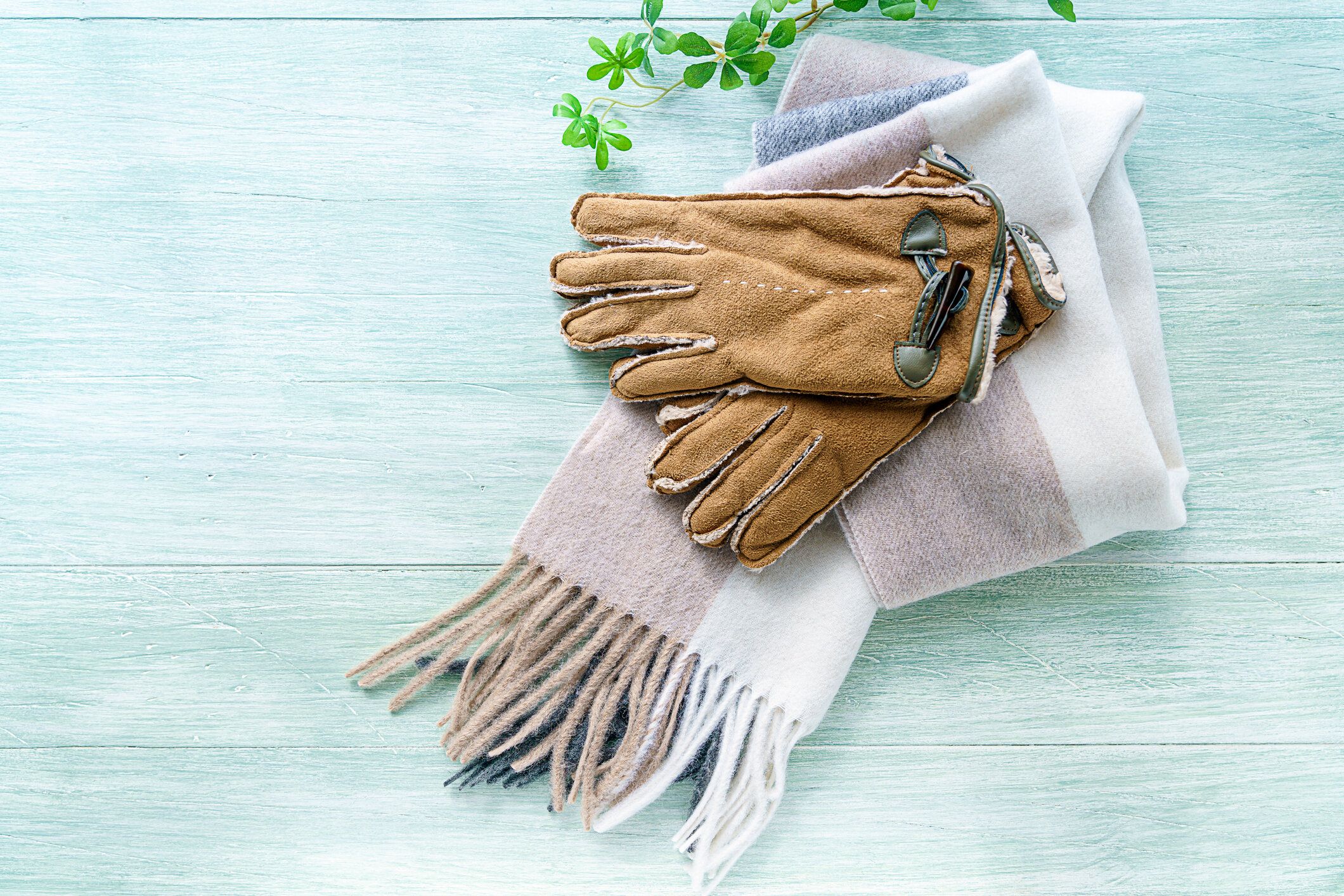 木製の背景にウールのスカーフと手袋