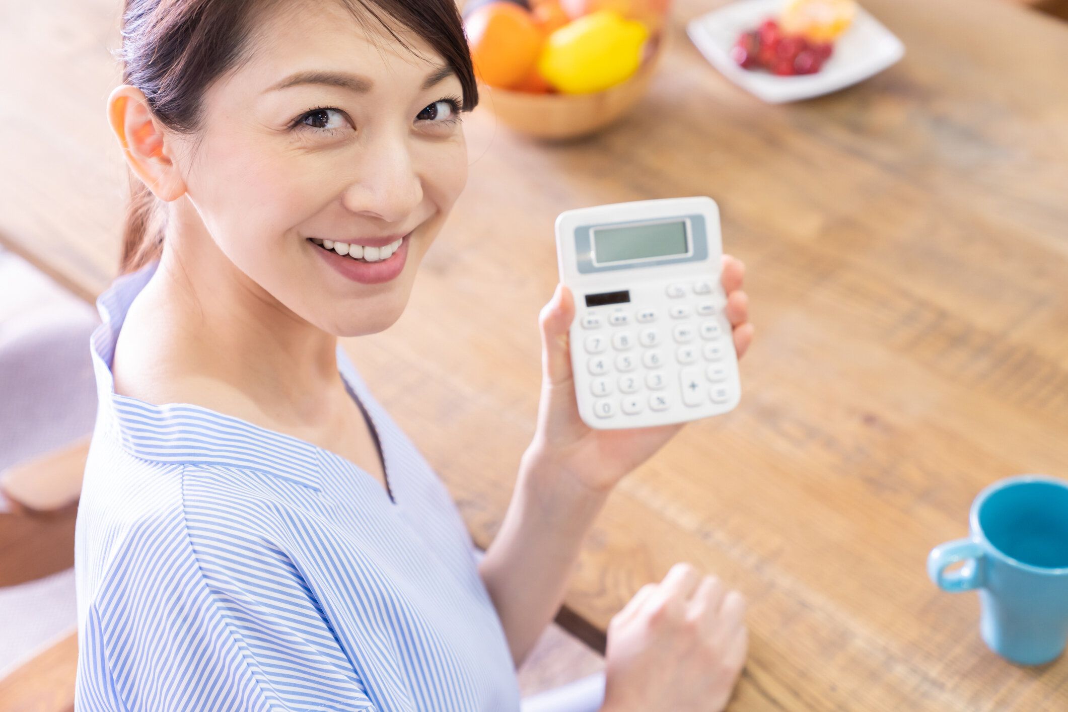 電子電卓を持つ笑顔の女性