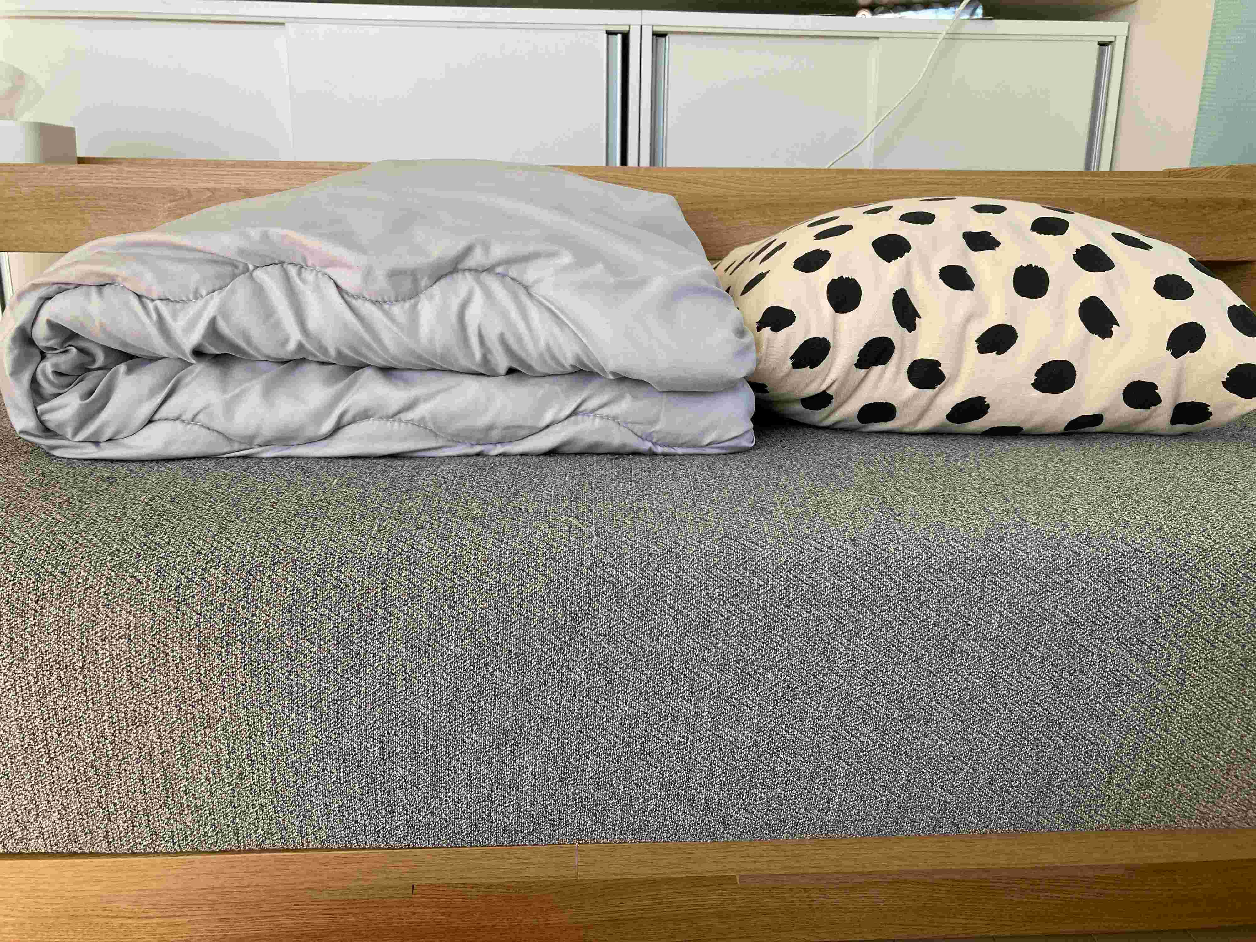 畳んだ布団とクッションの厚さを比較している