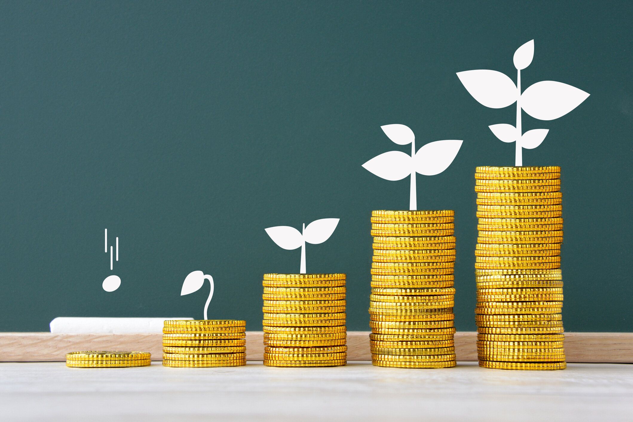 黒板にコインを積み上げて描いた芽の成長