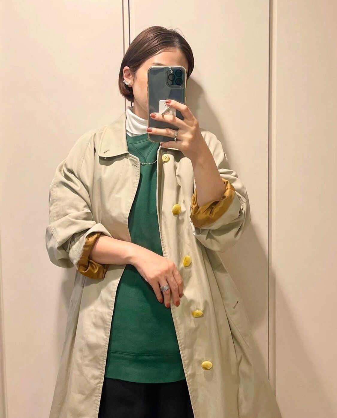 グリーンのスウェットにベージュのコート