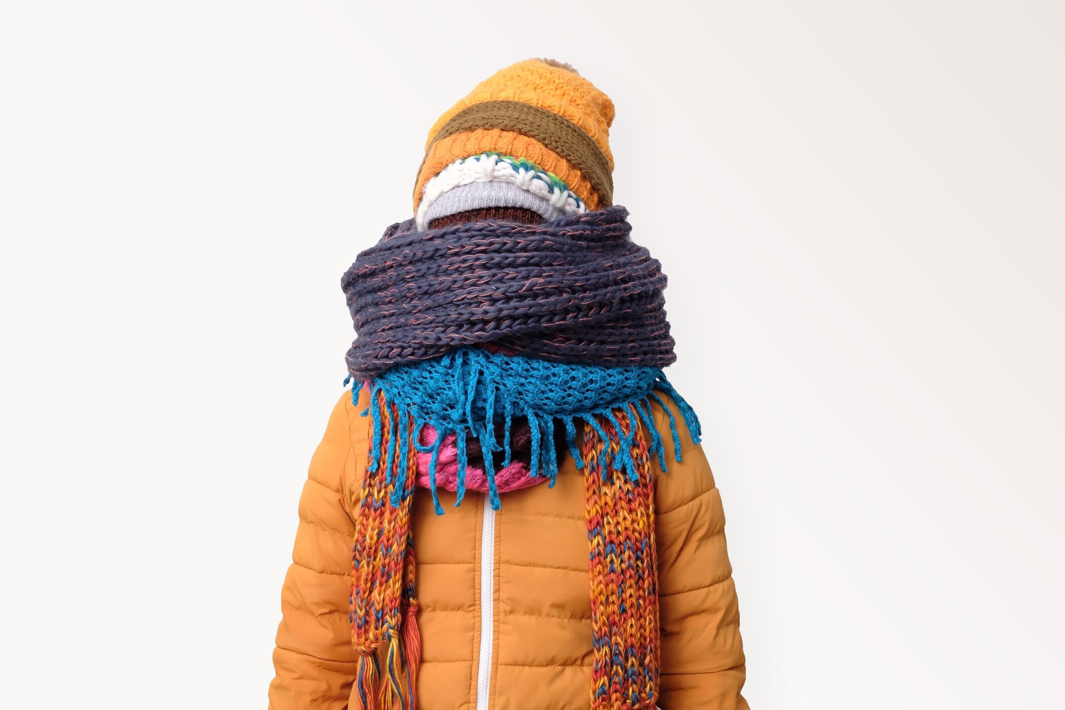 ハンサムな白人面白い男は、いくつかの帽子やスカーフに顔を隠しています。