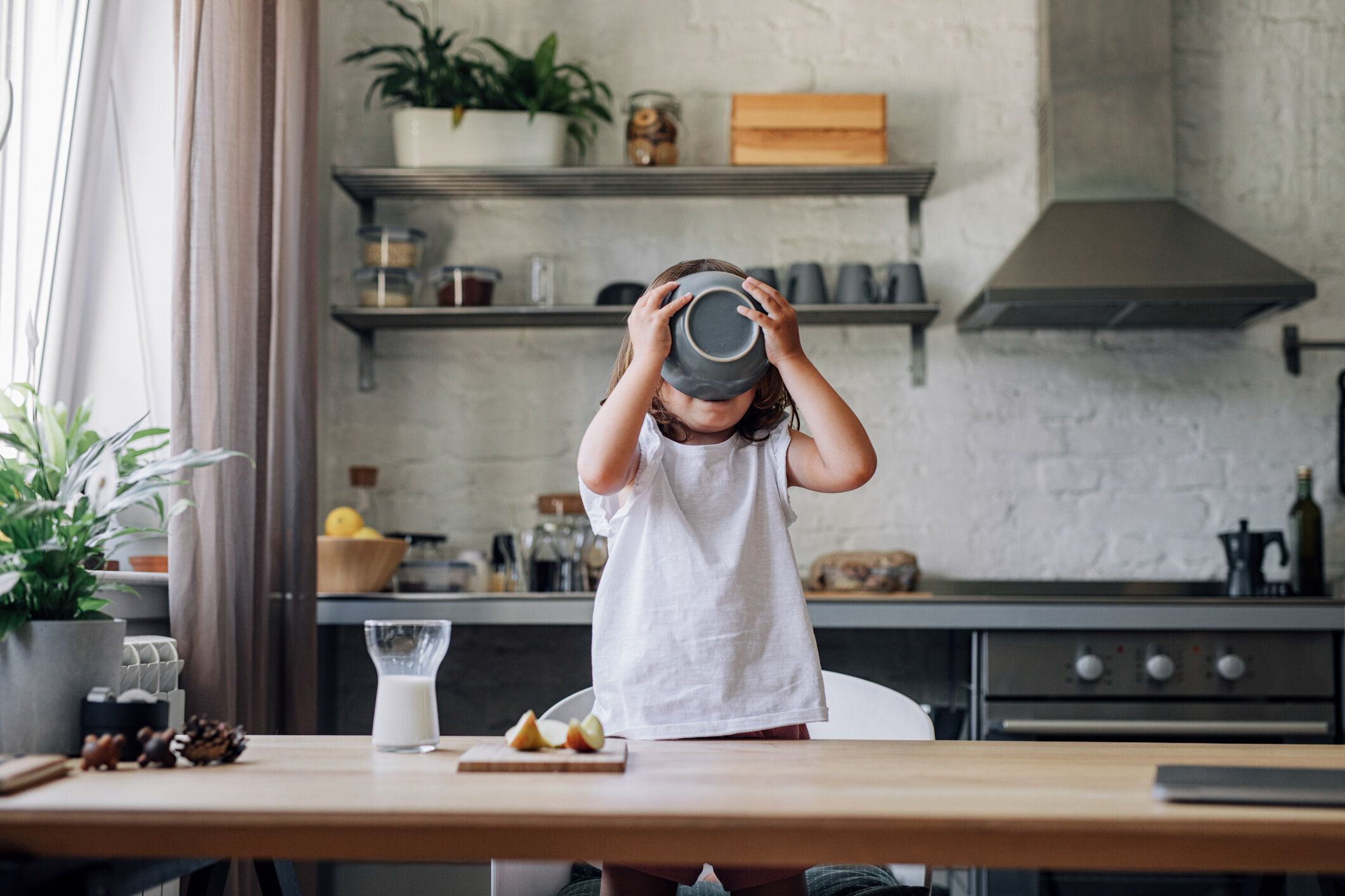 ダイニングルームで朝食にシリアルを食べるハッピーヤングガール