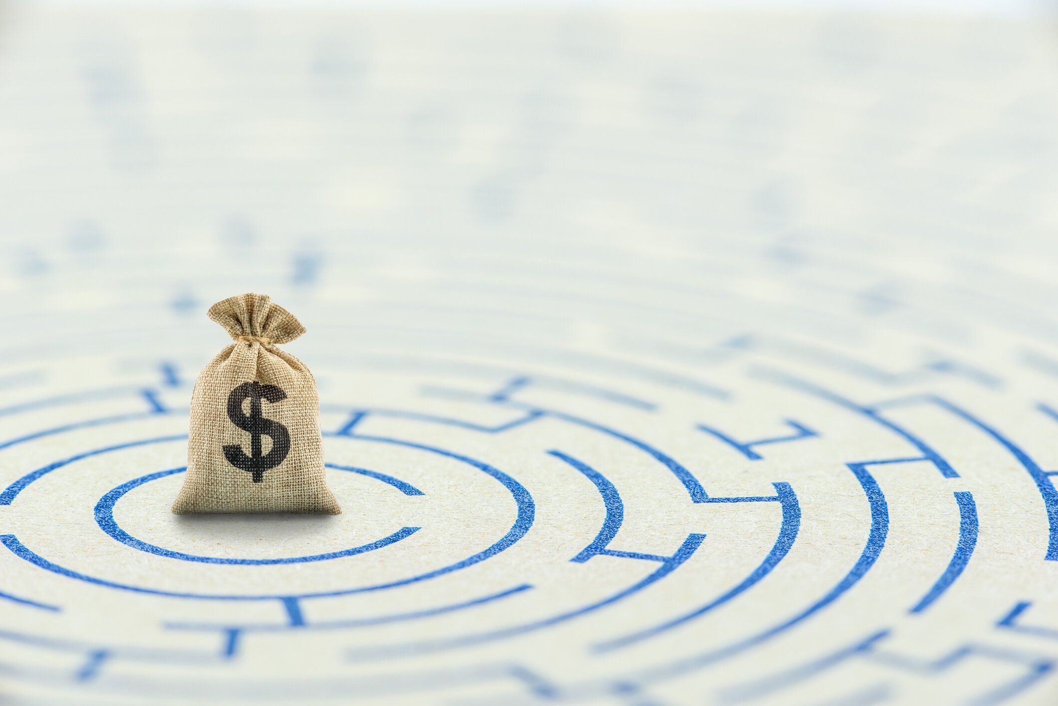 金融障壁を縮小、除去、または克服する、金融コンセプト:迷路パズルの上の米ドルバッグ。