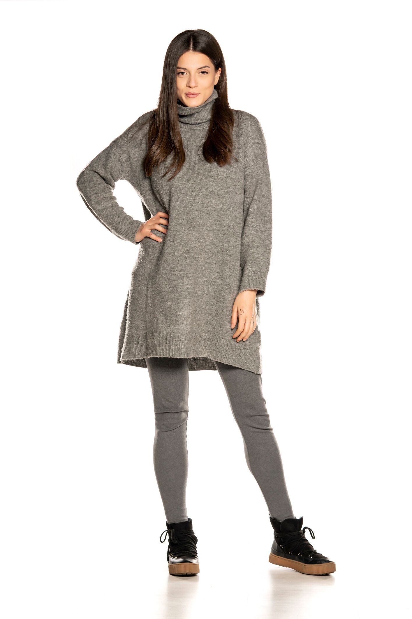 白い背景に灰色のチュニックで若い美しい女性