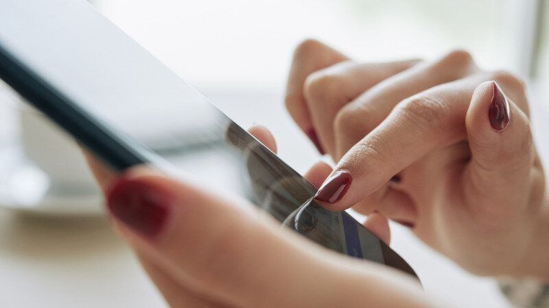 スマホでメルカリをする女性