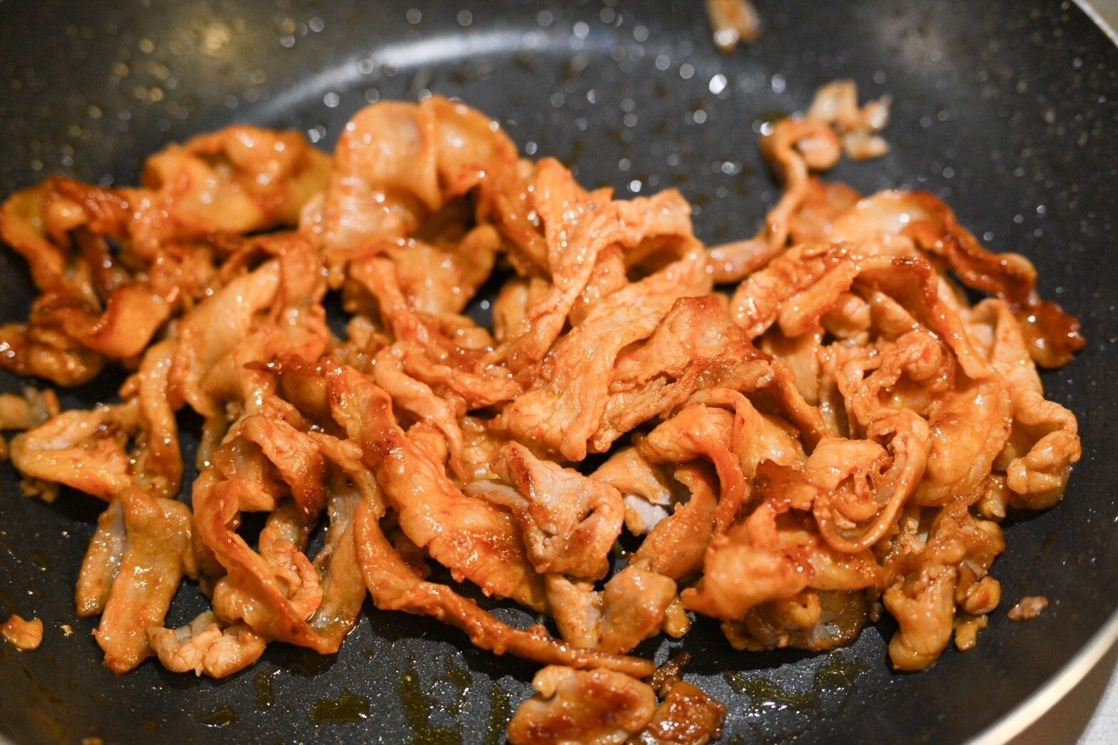 フライパンに入った炒めた豚バラ肉