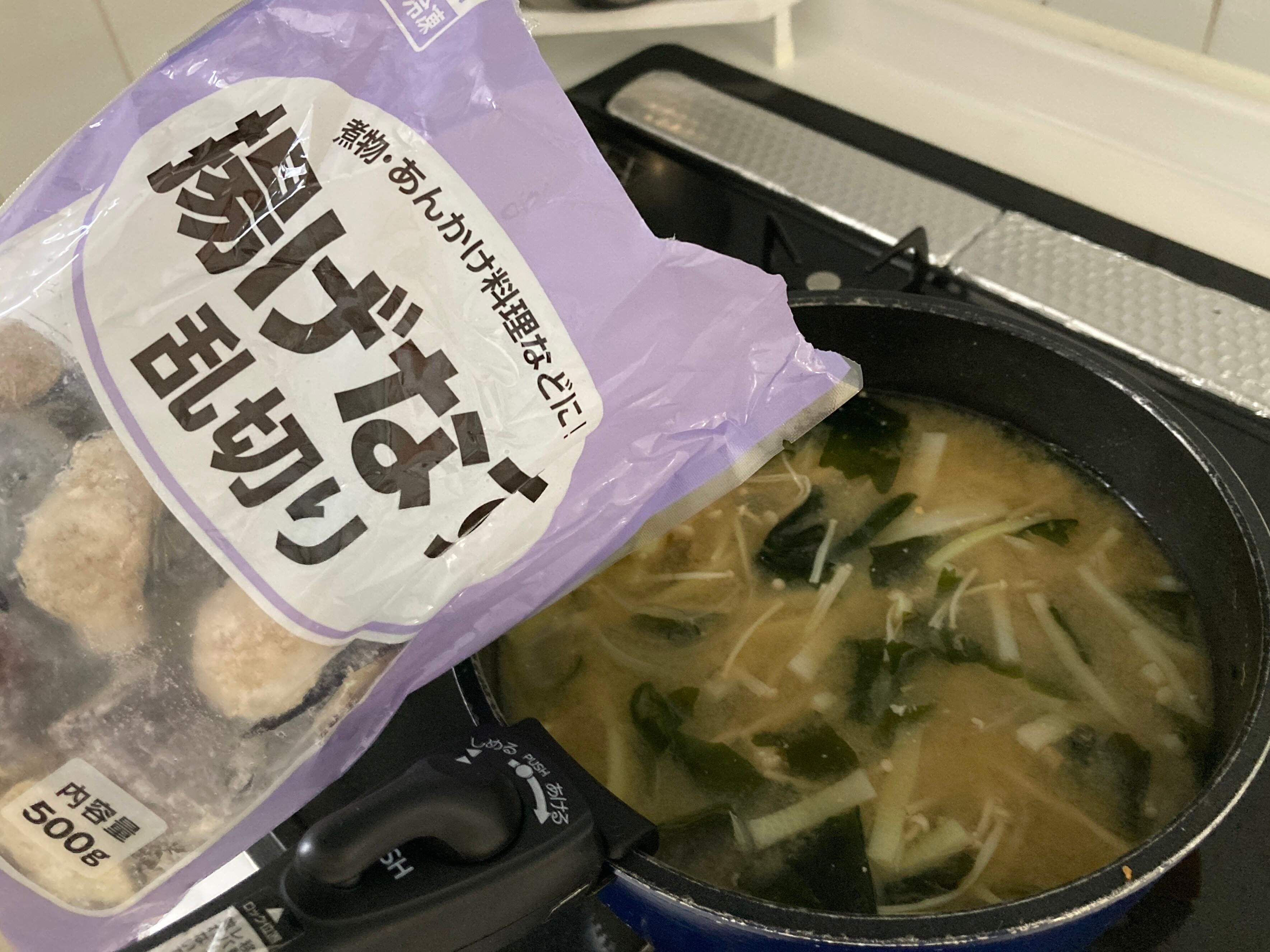 お味噌汁に冷凍の揚げなすを入れようとしているところ