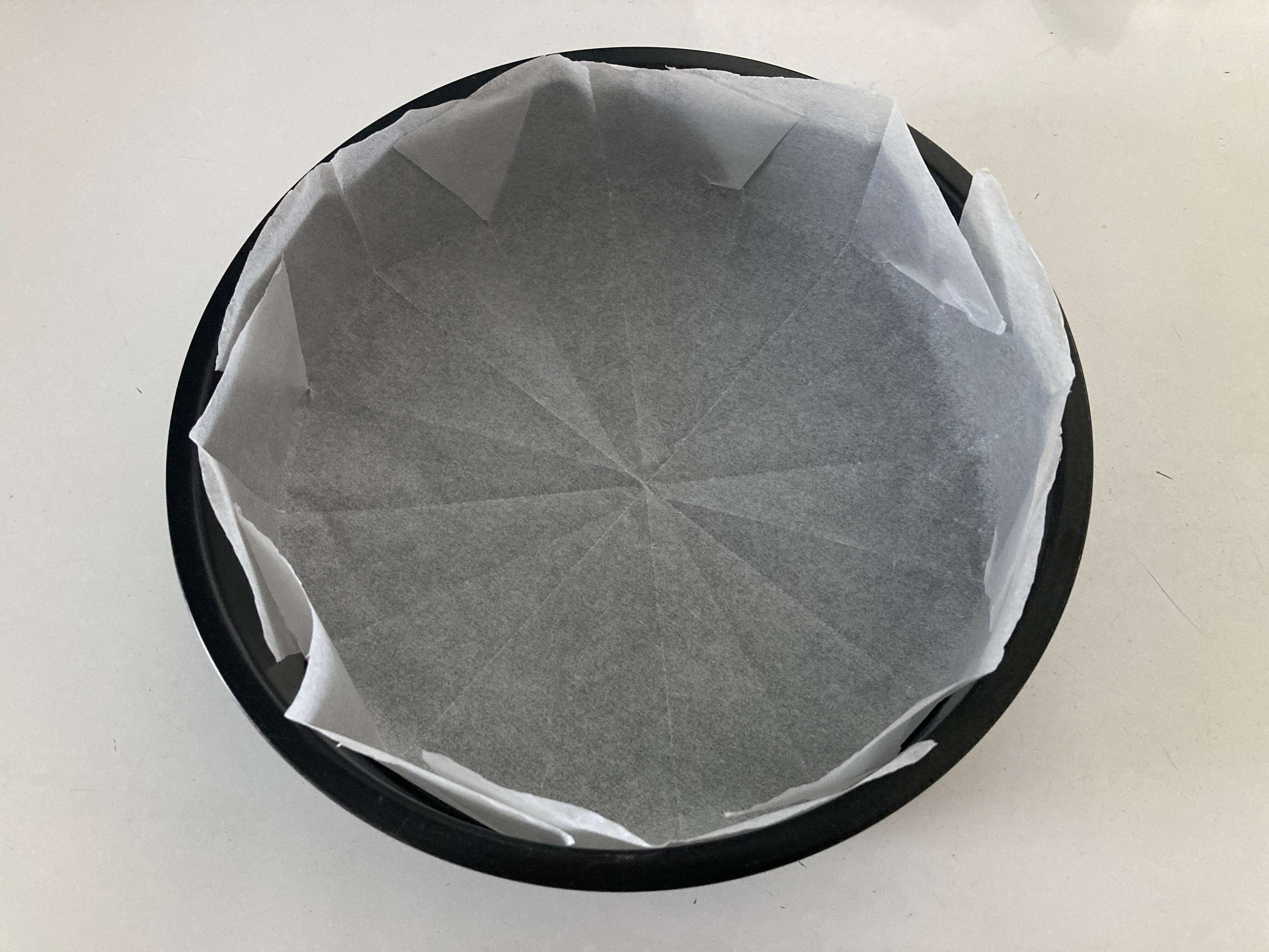 ケーキの型にクッキングシートを敷いている