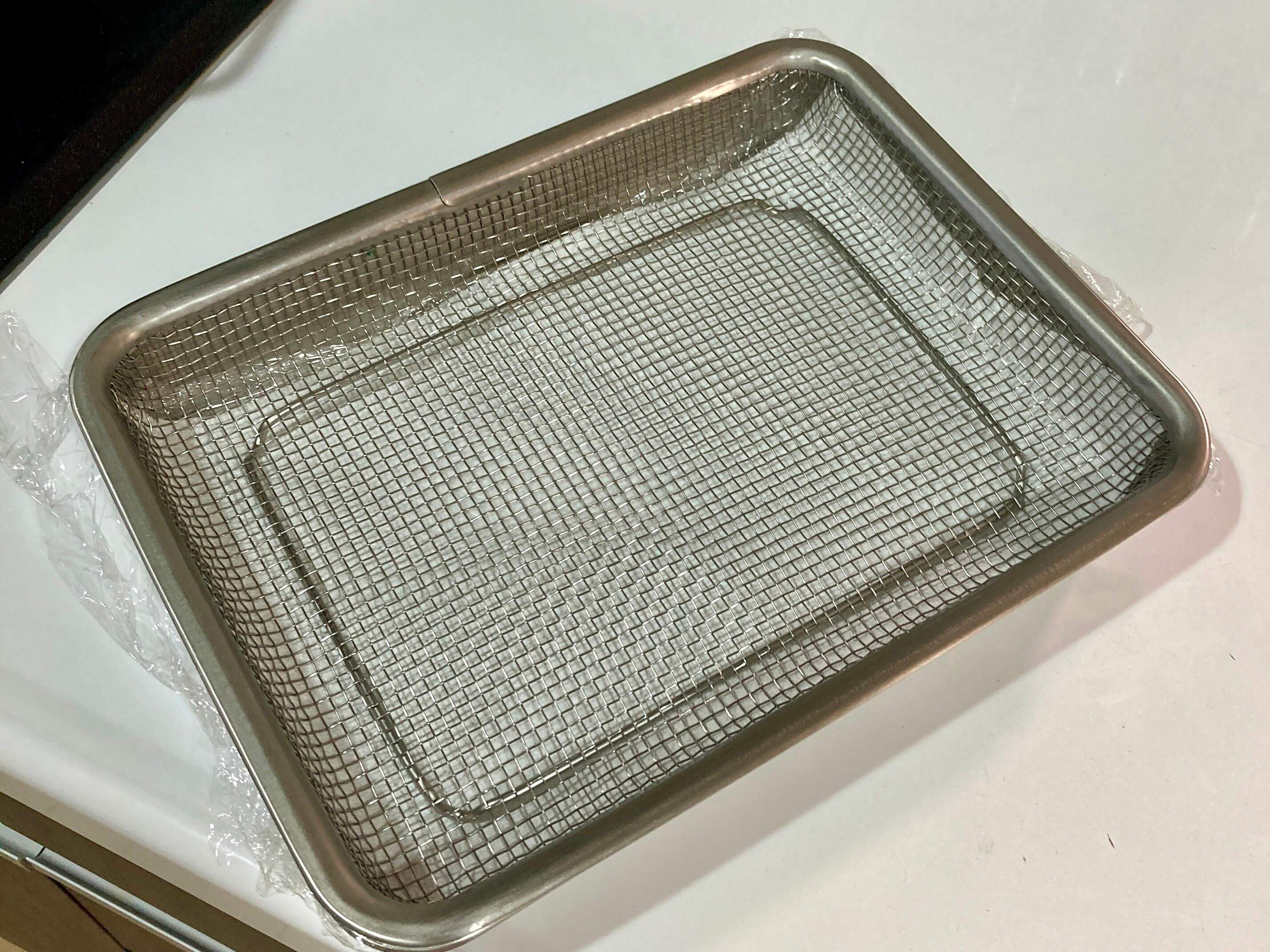 バットとメッシュトレーの間にラップとキッチンペーパーが敷かれている揚げ物バット