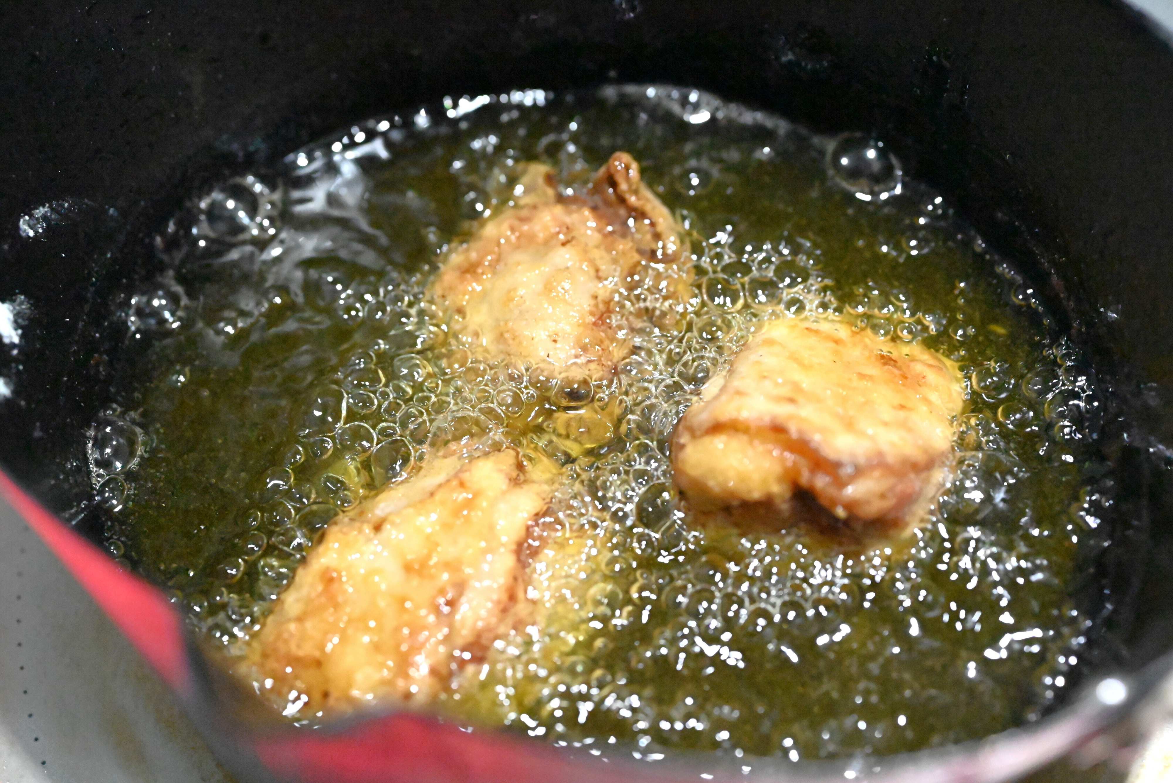 揚げ油に入った唐揚げ