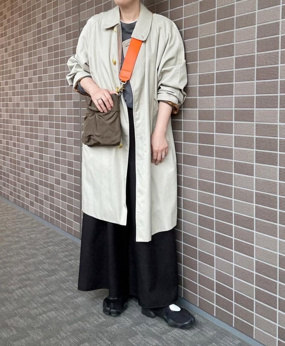 ベージュコートと黒パンツ