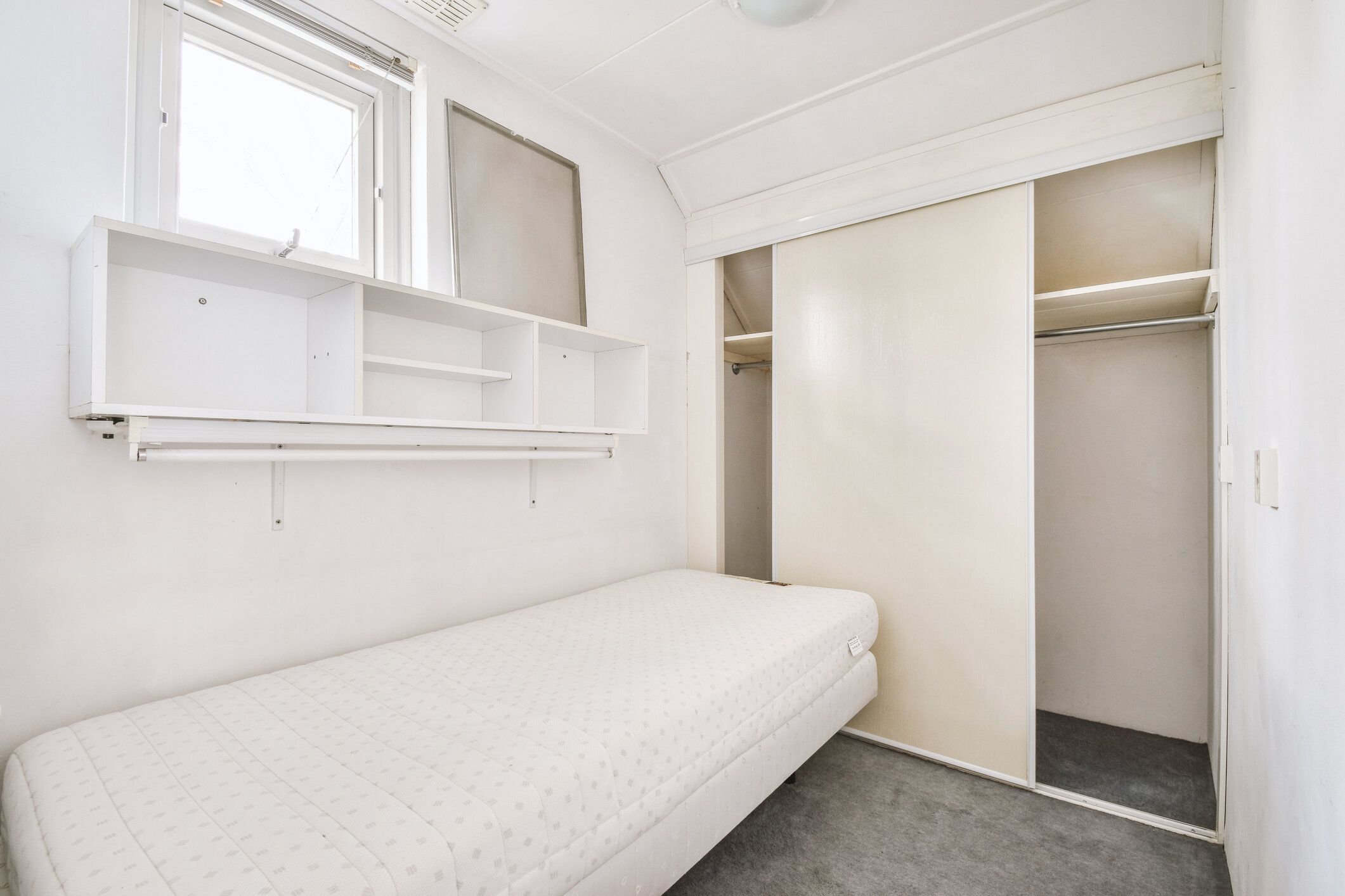 白い壁の明るいシンプルなベッドルームインテリア