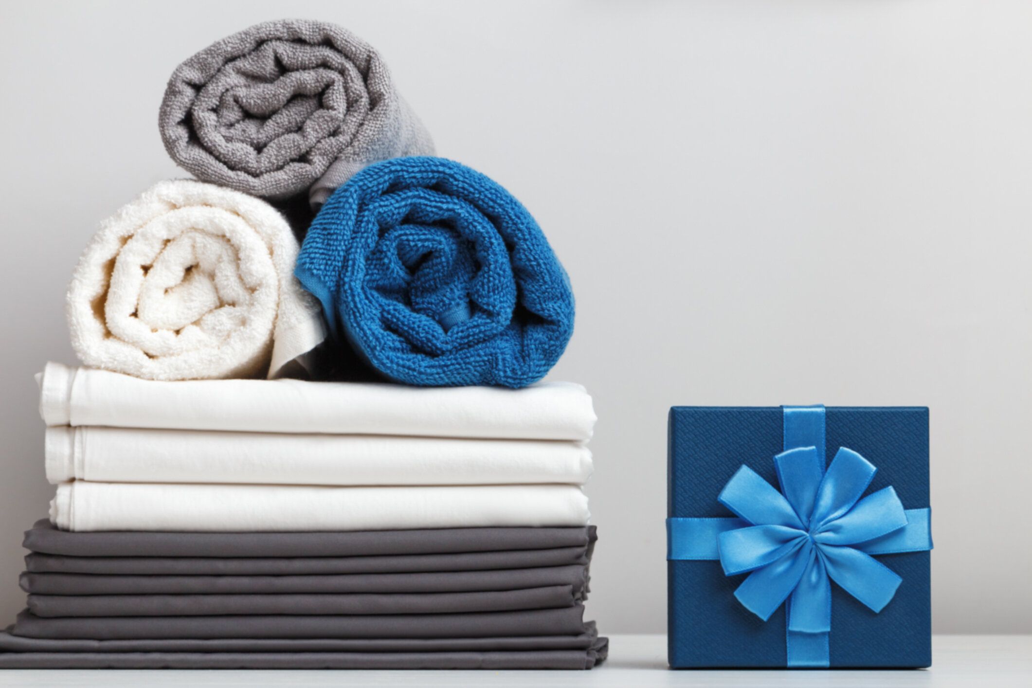 テーブルの上にベッドリネンシーツタオルギフトボックスのスタック