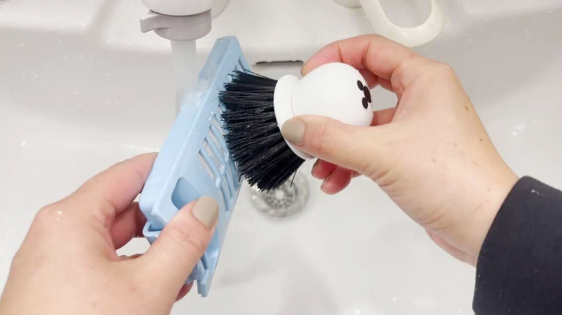糸くずフィルターをブラシでこする