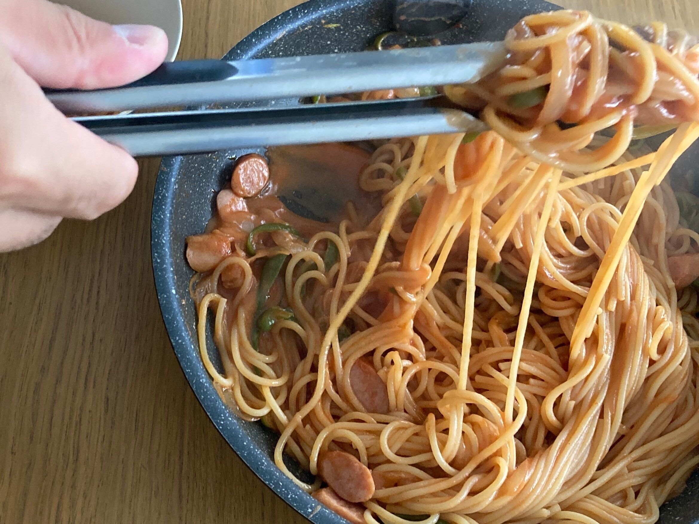 ナポリタンをトングで持ち上げている