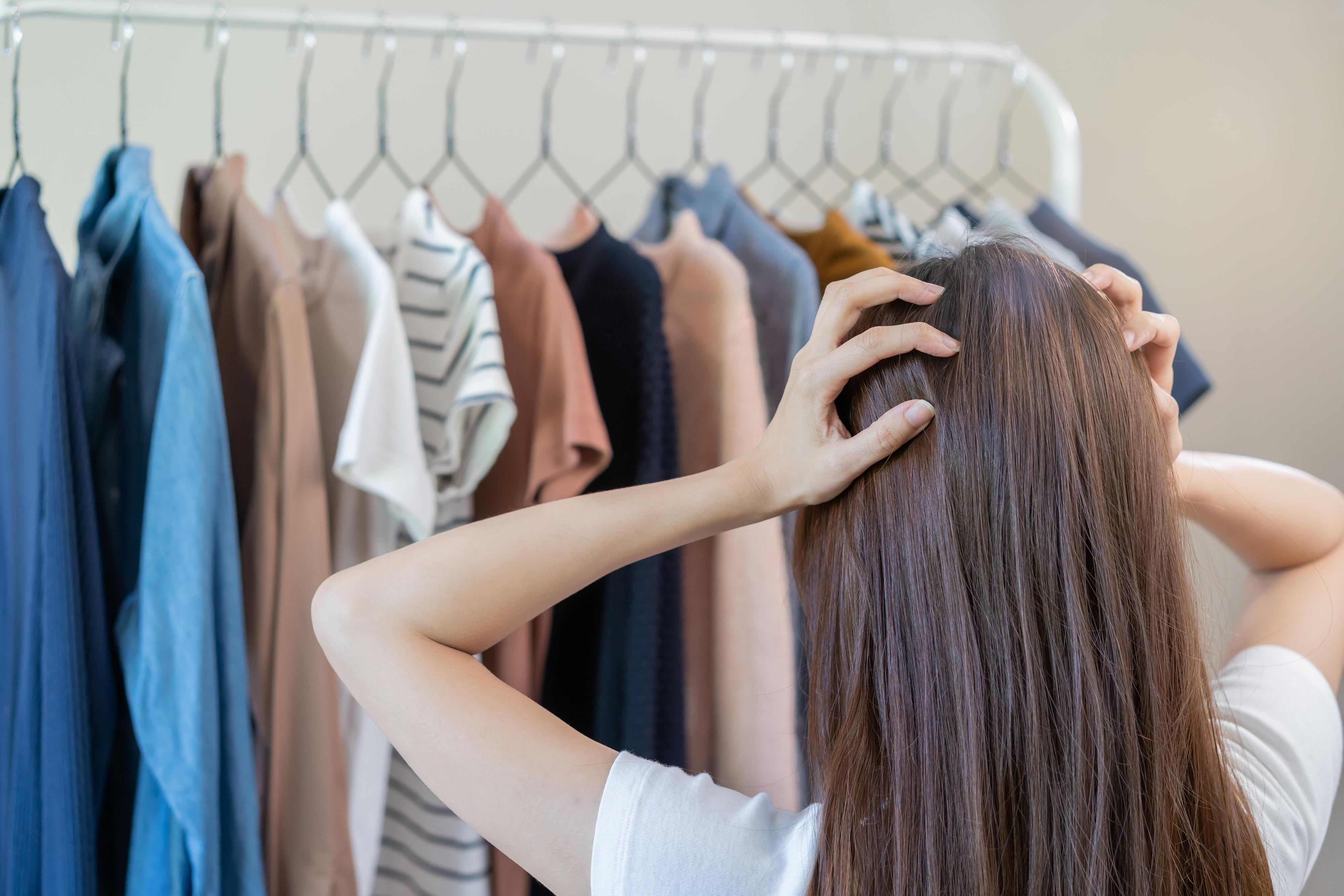 クローゼットの前で頭を抱える女性