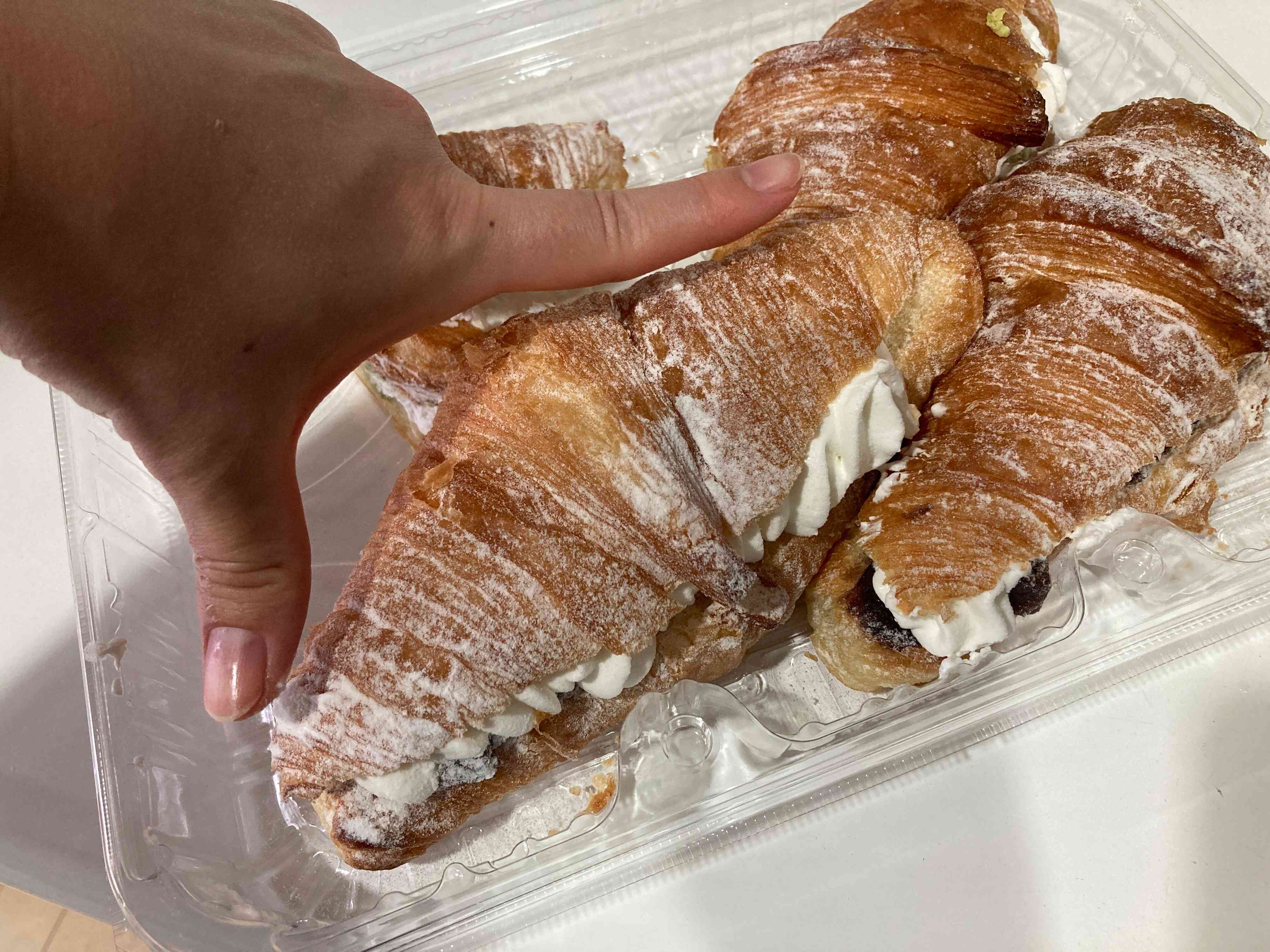 クロワッサンの大きさを親指と人差し指で測っている