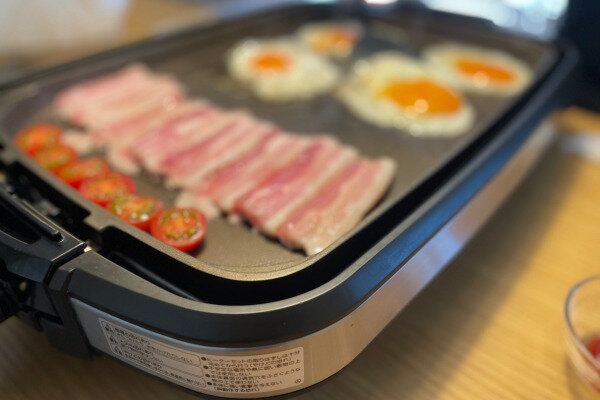 ホットプレートで食材を焼いている場面