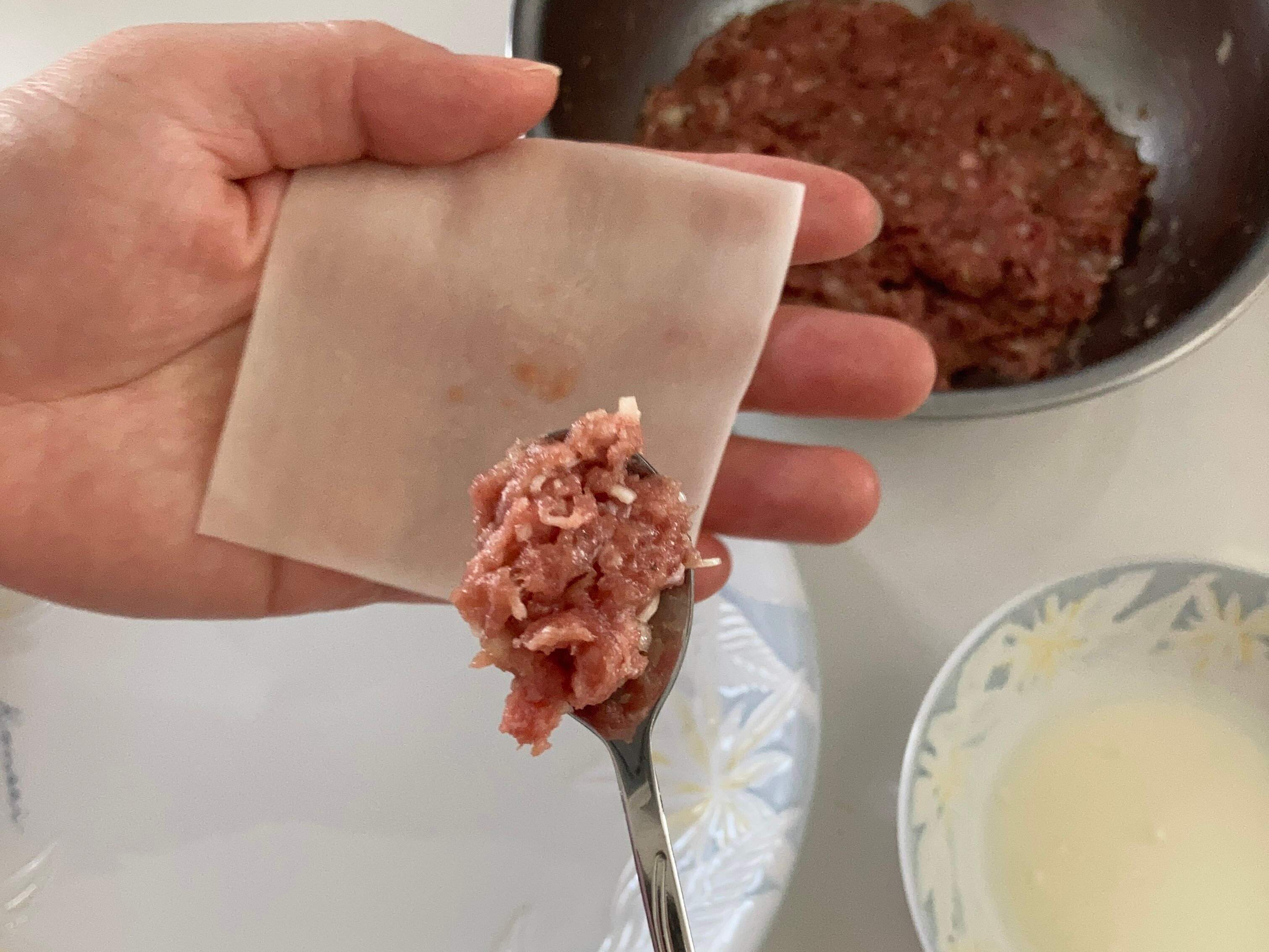 ワンタンの皮に肉だねを小さじ1杯のせている