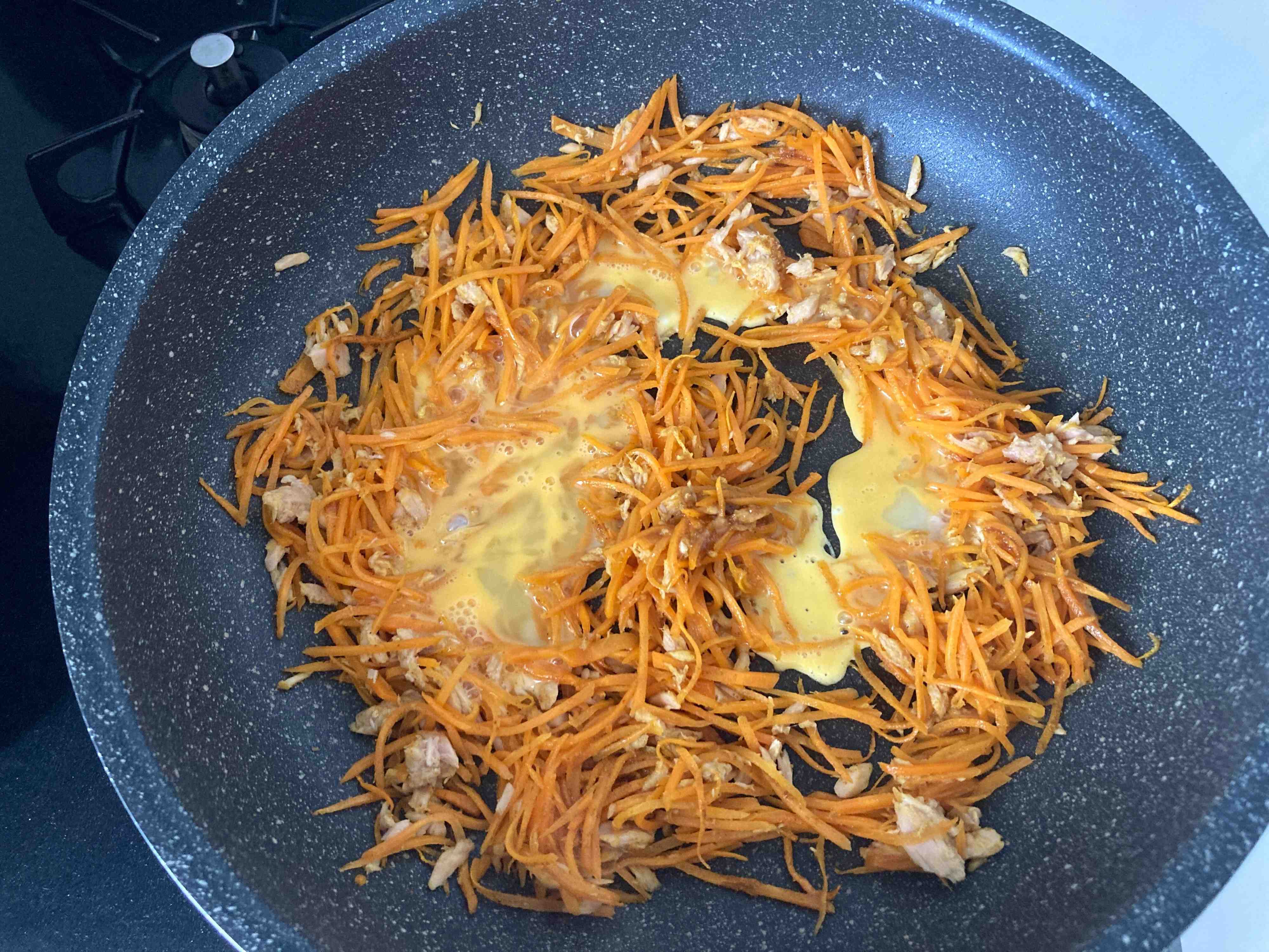 ツナとにんじんを炒めたところに卵液を入れたところ