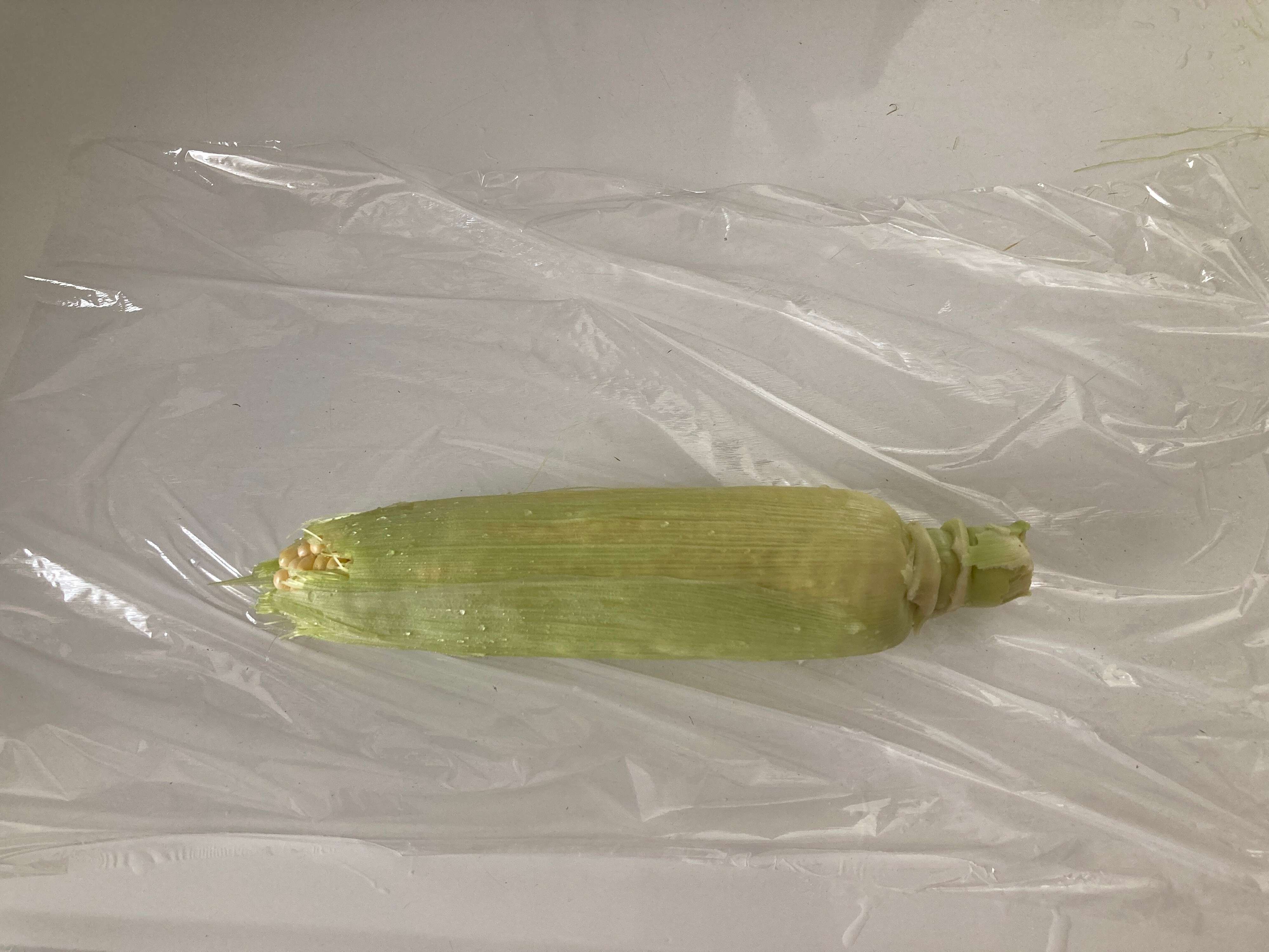 水洗いしたとうもろこしをラップで包む