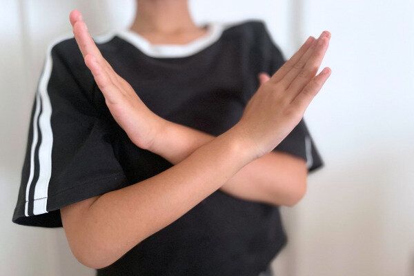 ☓のジェスチャーをする子ども