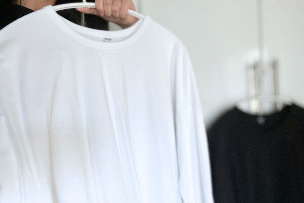 服をあてて着るかどうか悩む様子