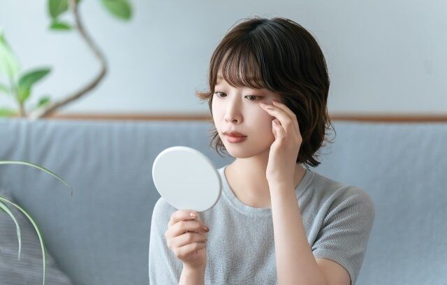 目元を鏡で確認する女性