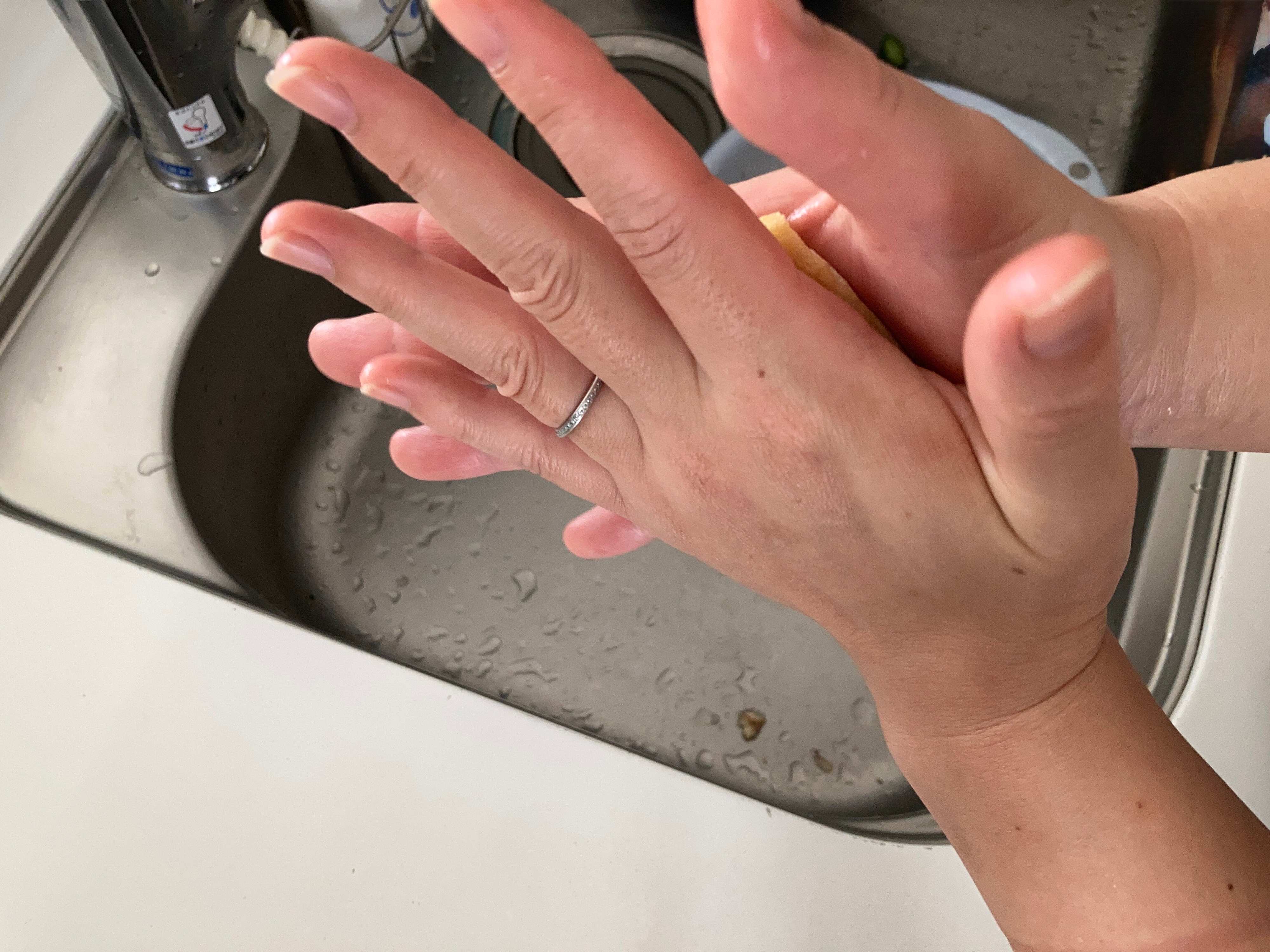 油揚げを手のひらで挟んでいる