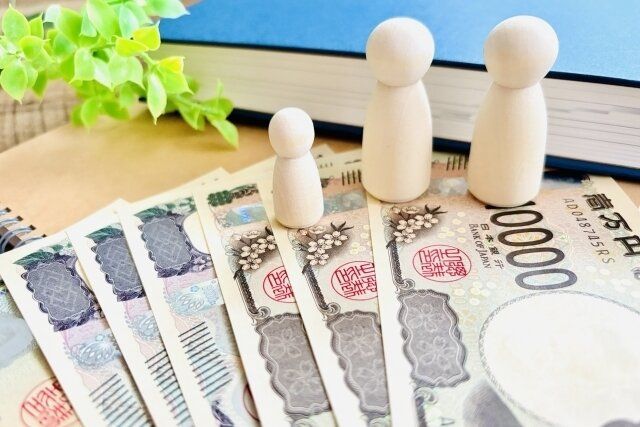 お札の上にのった人型の積み木