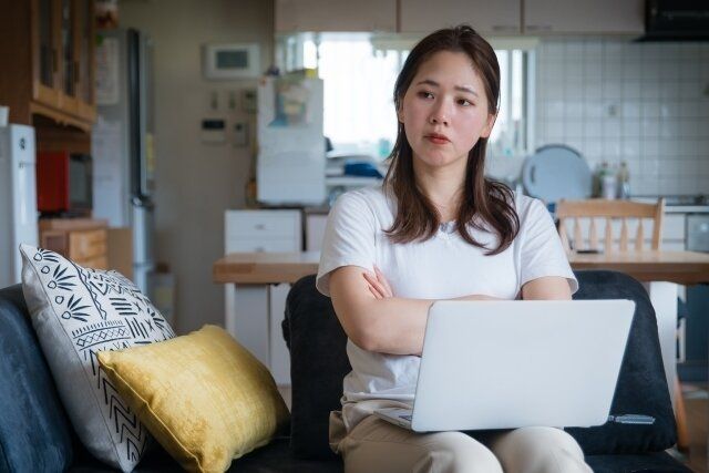 パソコンの前で悩む女性