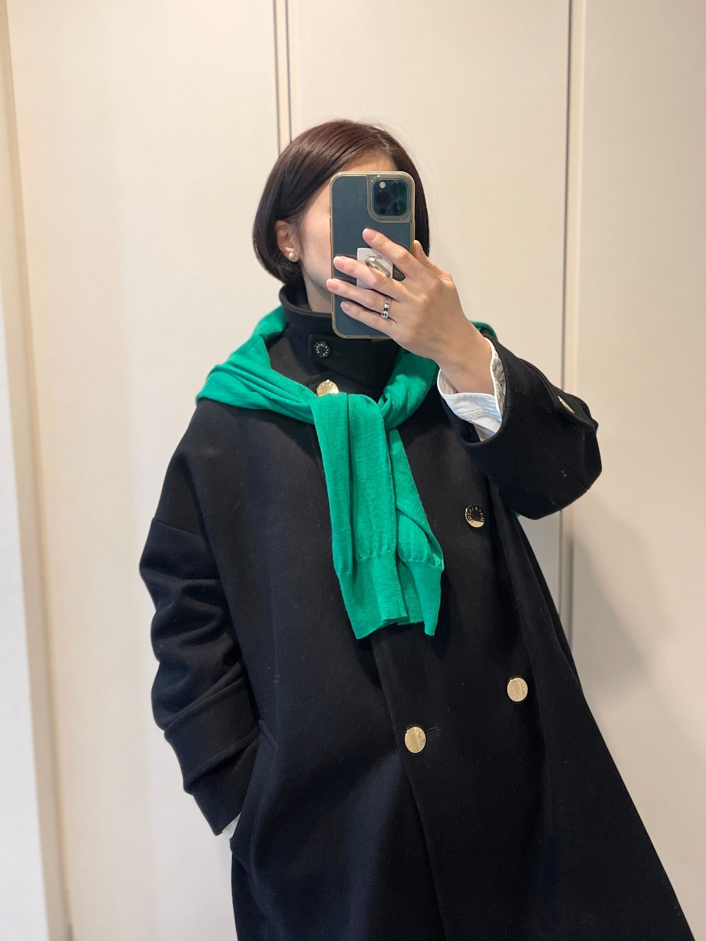 コートにグリーンカーディガン