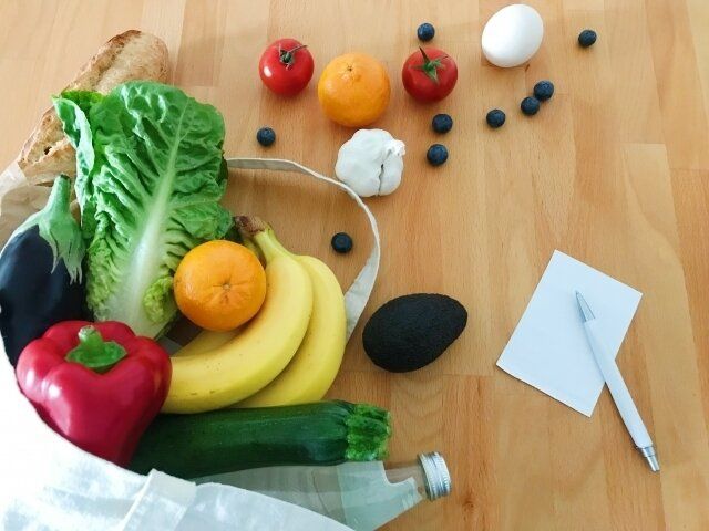 袋からはみ出た野菜とメモ帳