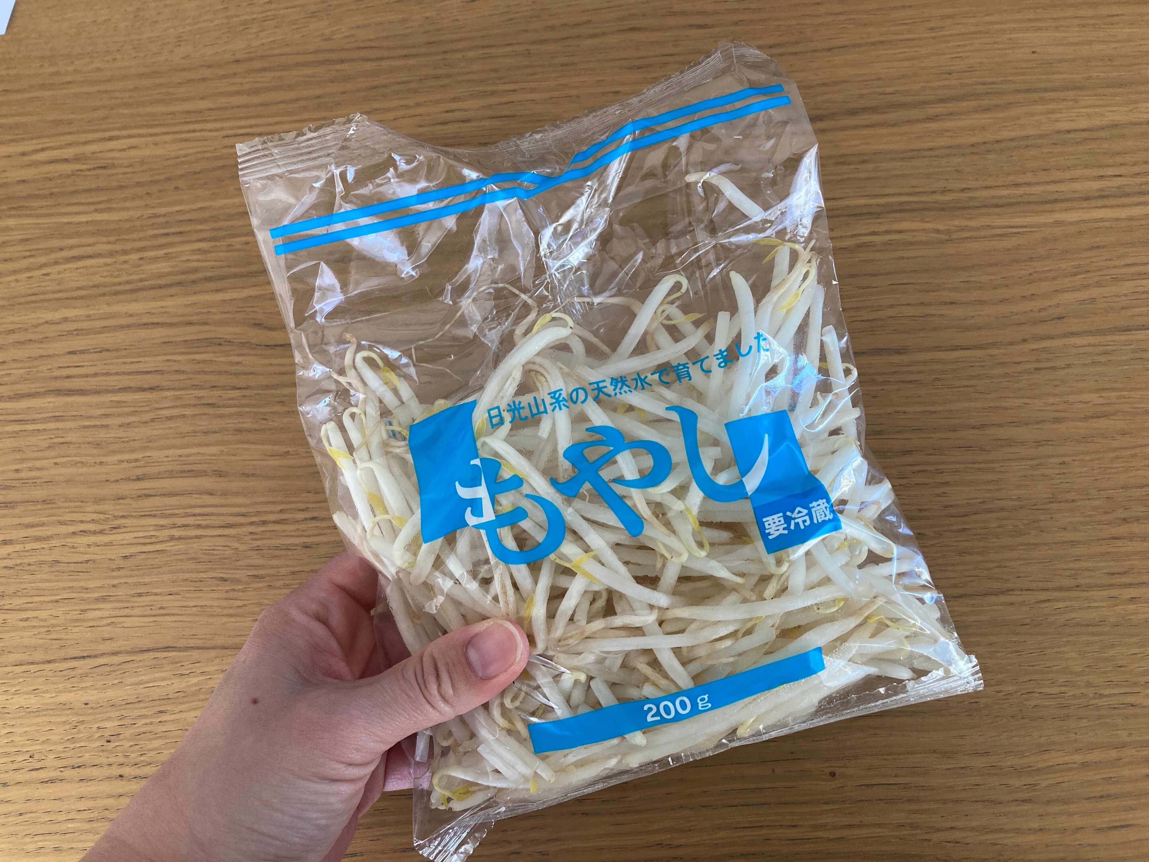 もやし1袋を手に持っている