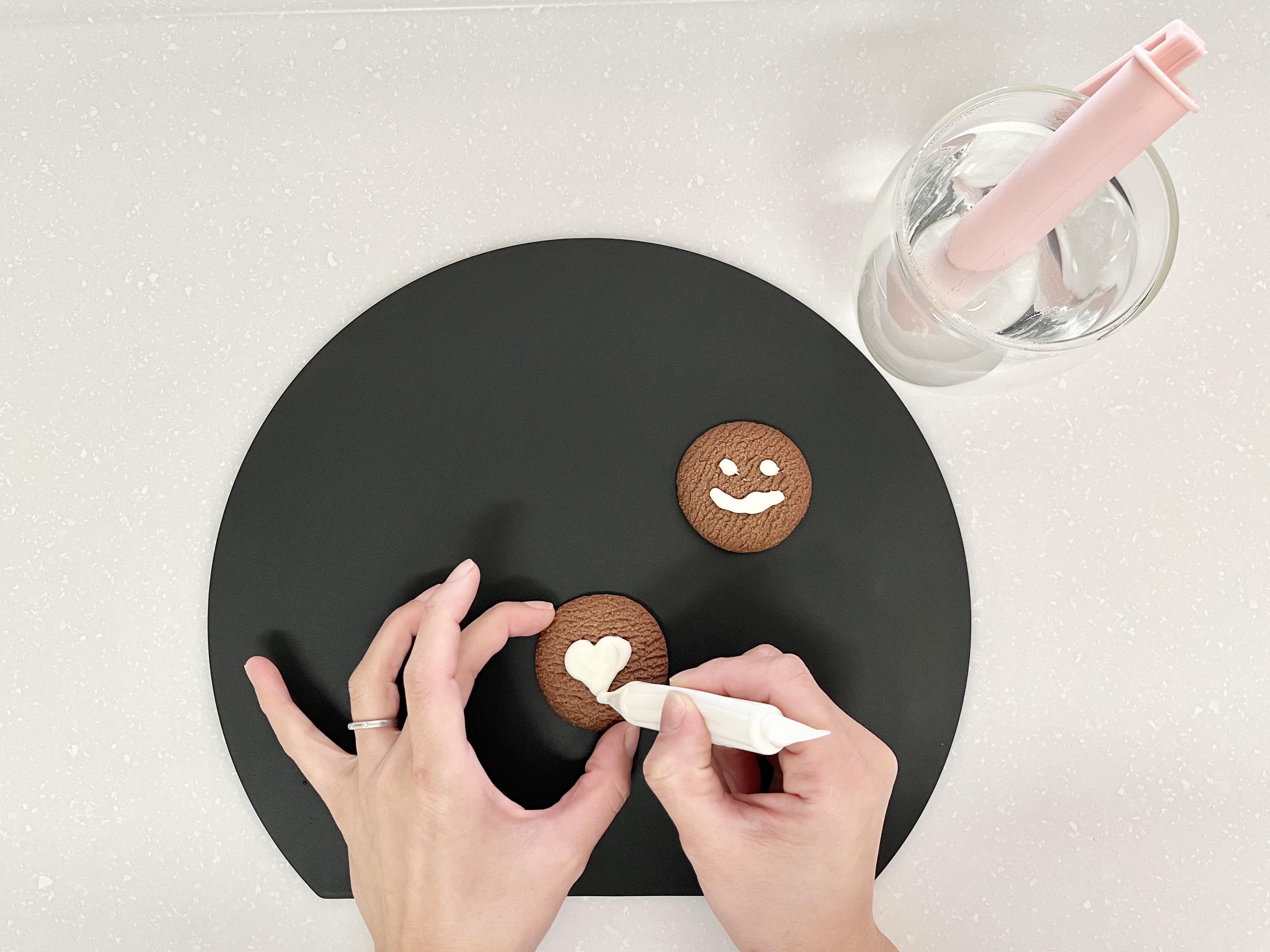 チョコレートペンでクッキーにデコレーションしている画像