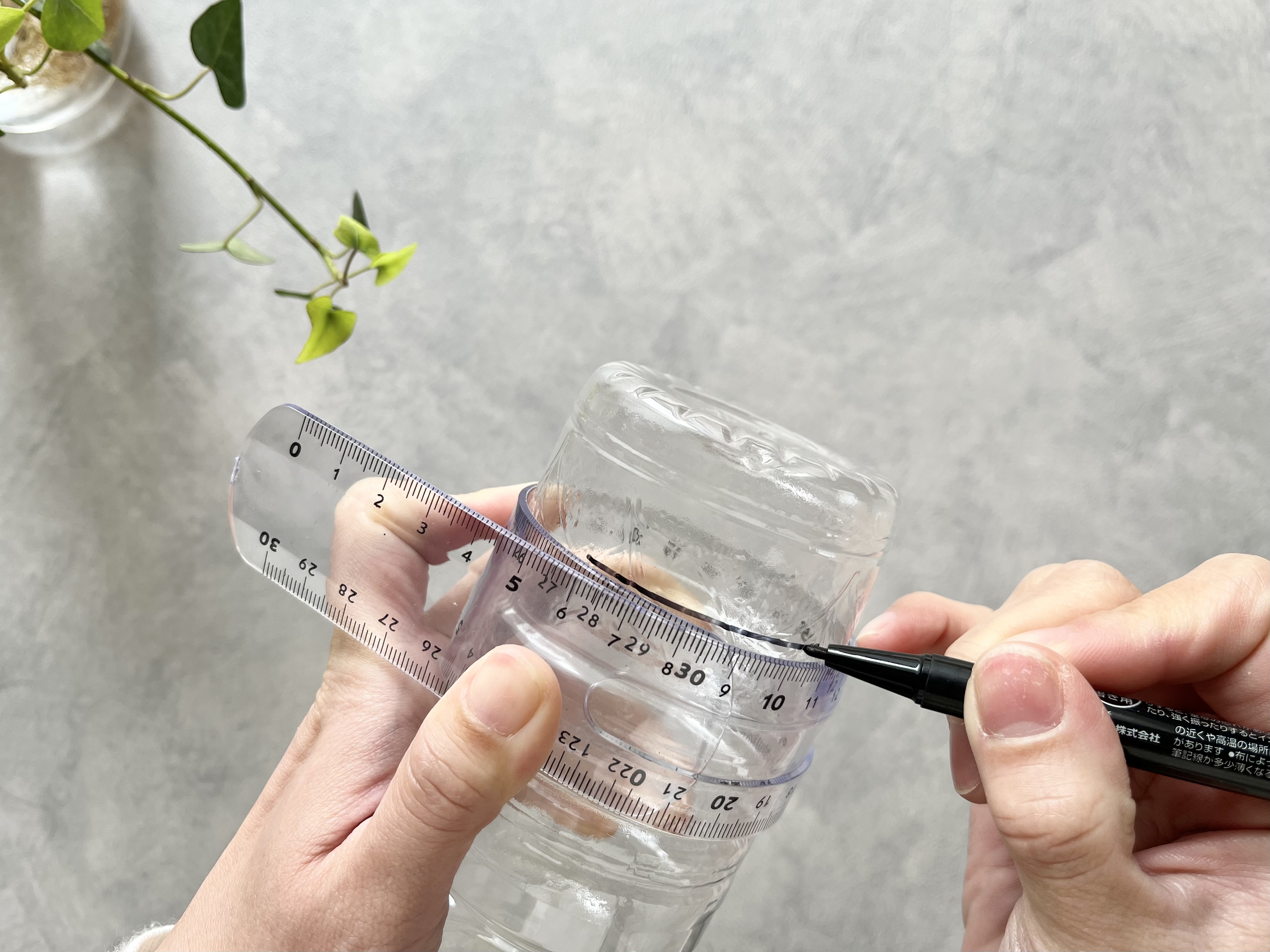 セリアの「やわらか定規」でペットボトルに線を引いている画像