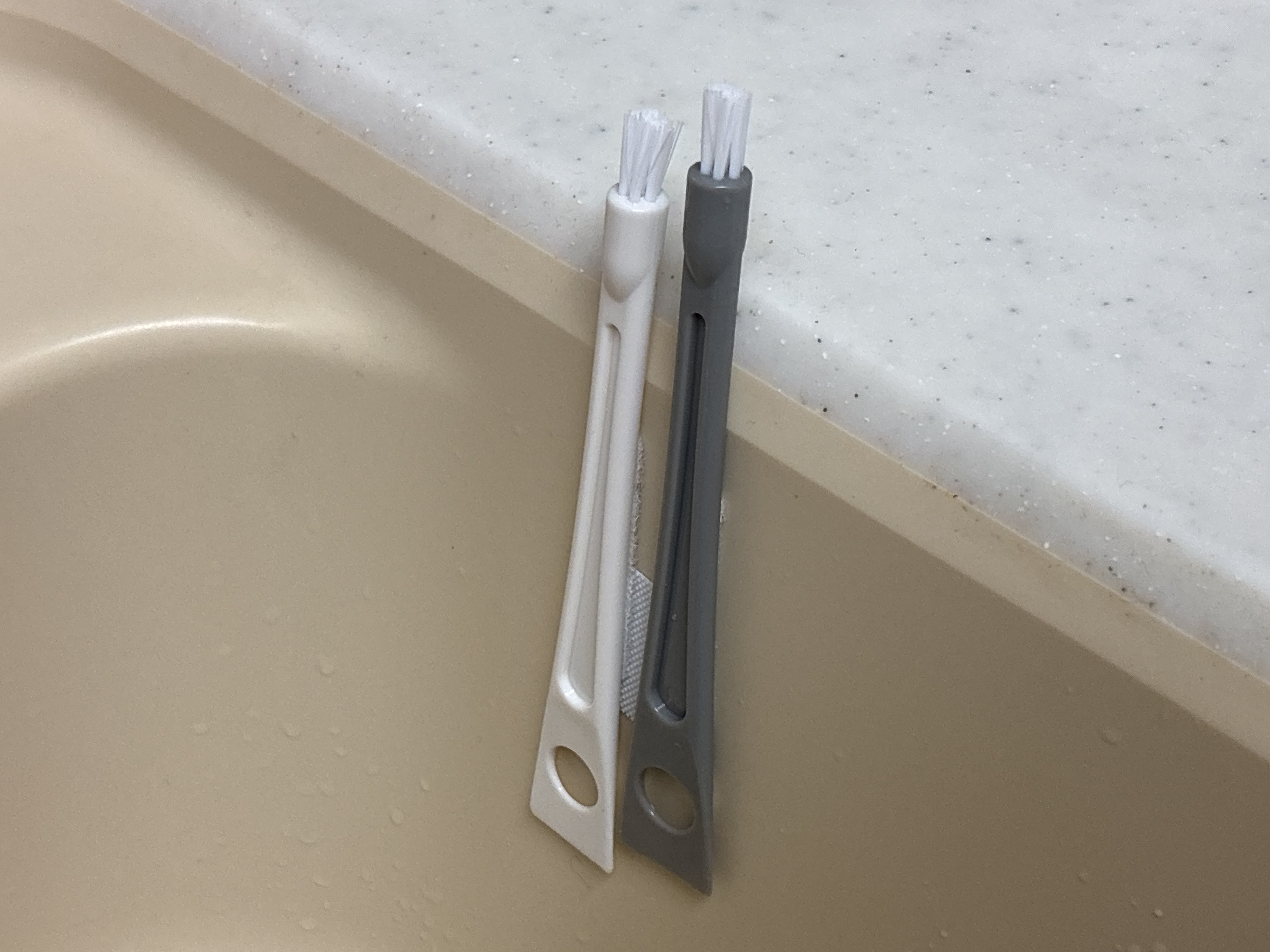 キッチンツールホルダーに隙間掃除ブラシを2本取り付けている様子