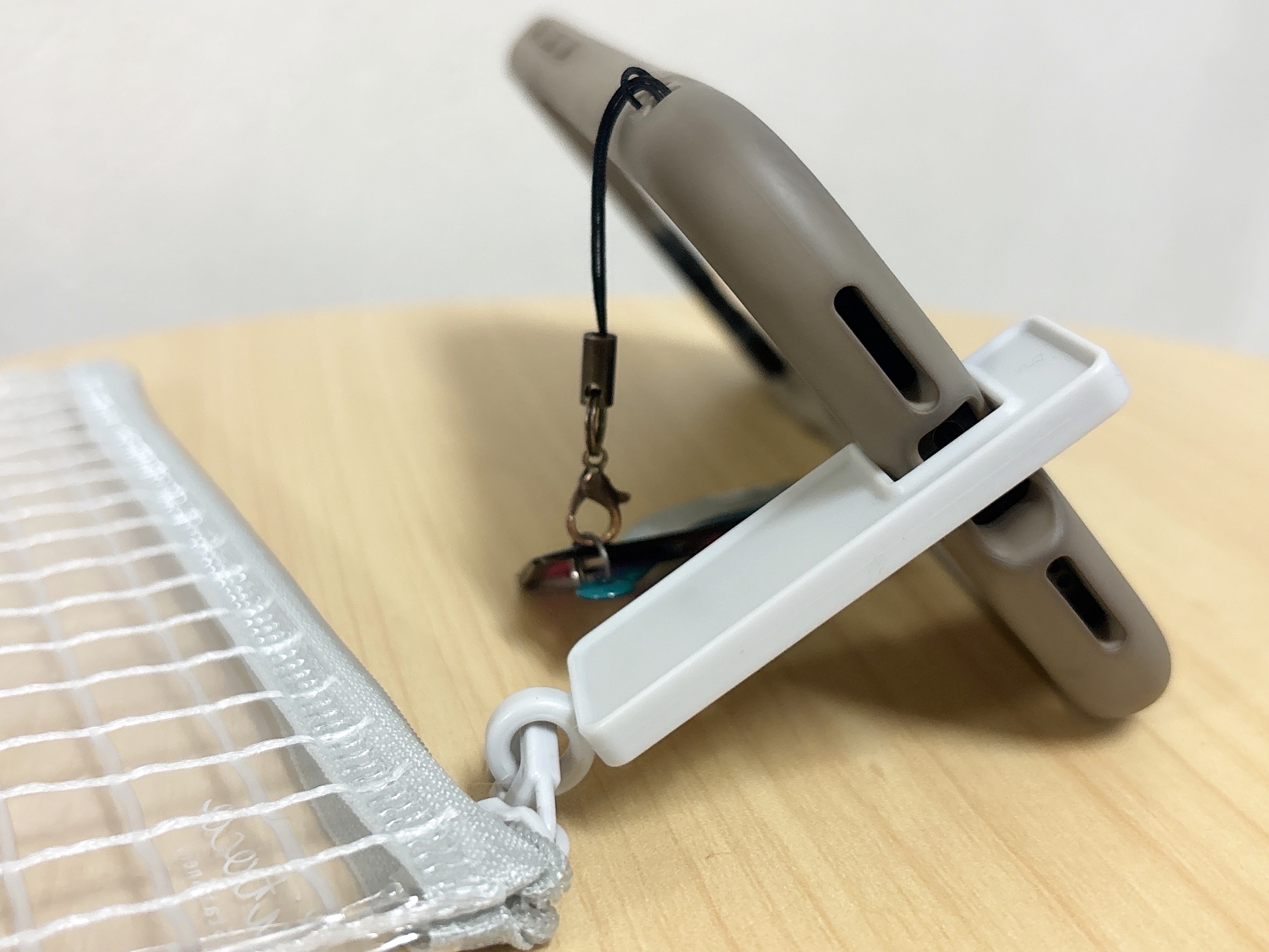 ダイソーのスマホが立てられるペンポーチのファスナーにスマホを立てている様子