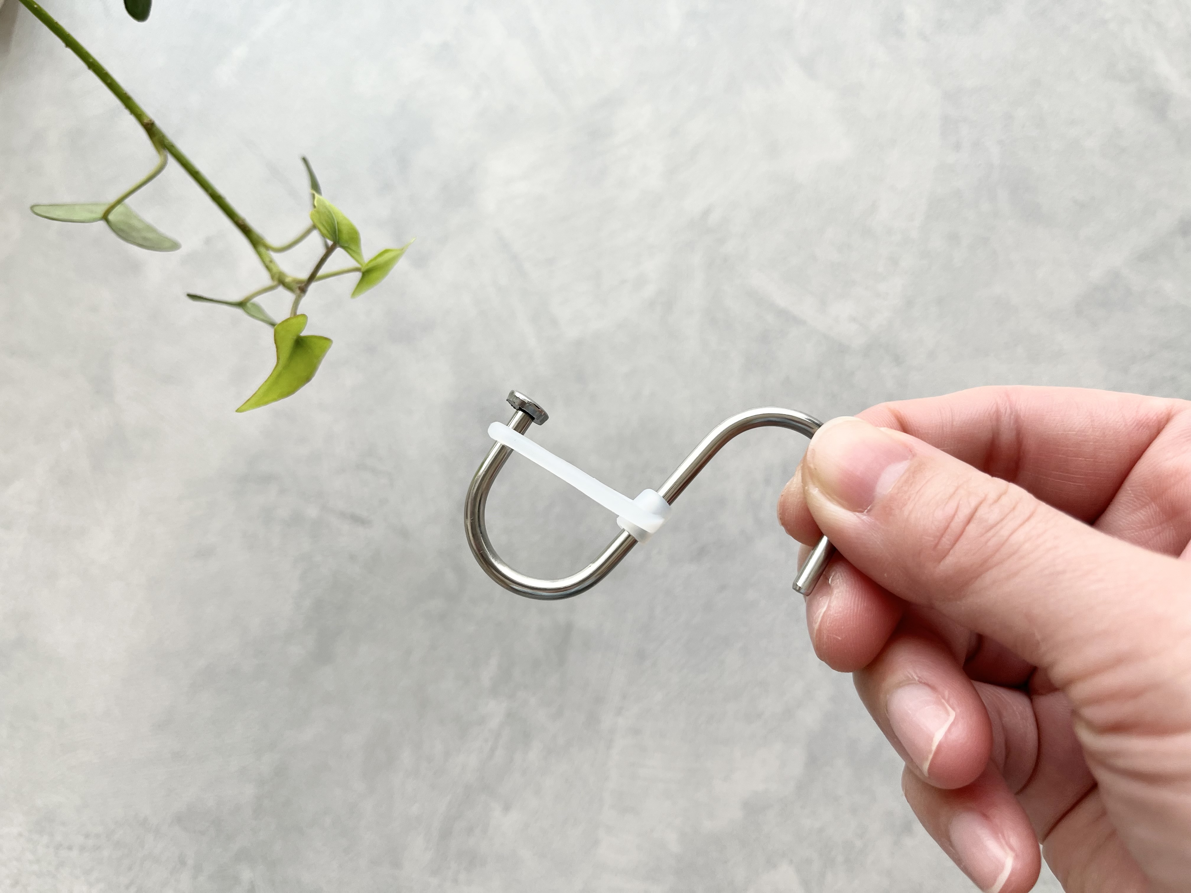 セリアの「シリコーンストッパー付きステンレスS字フック 小」を手に持った画像