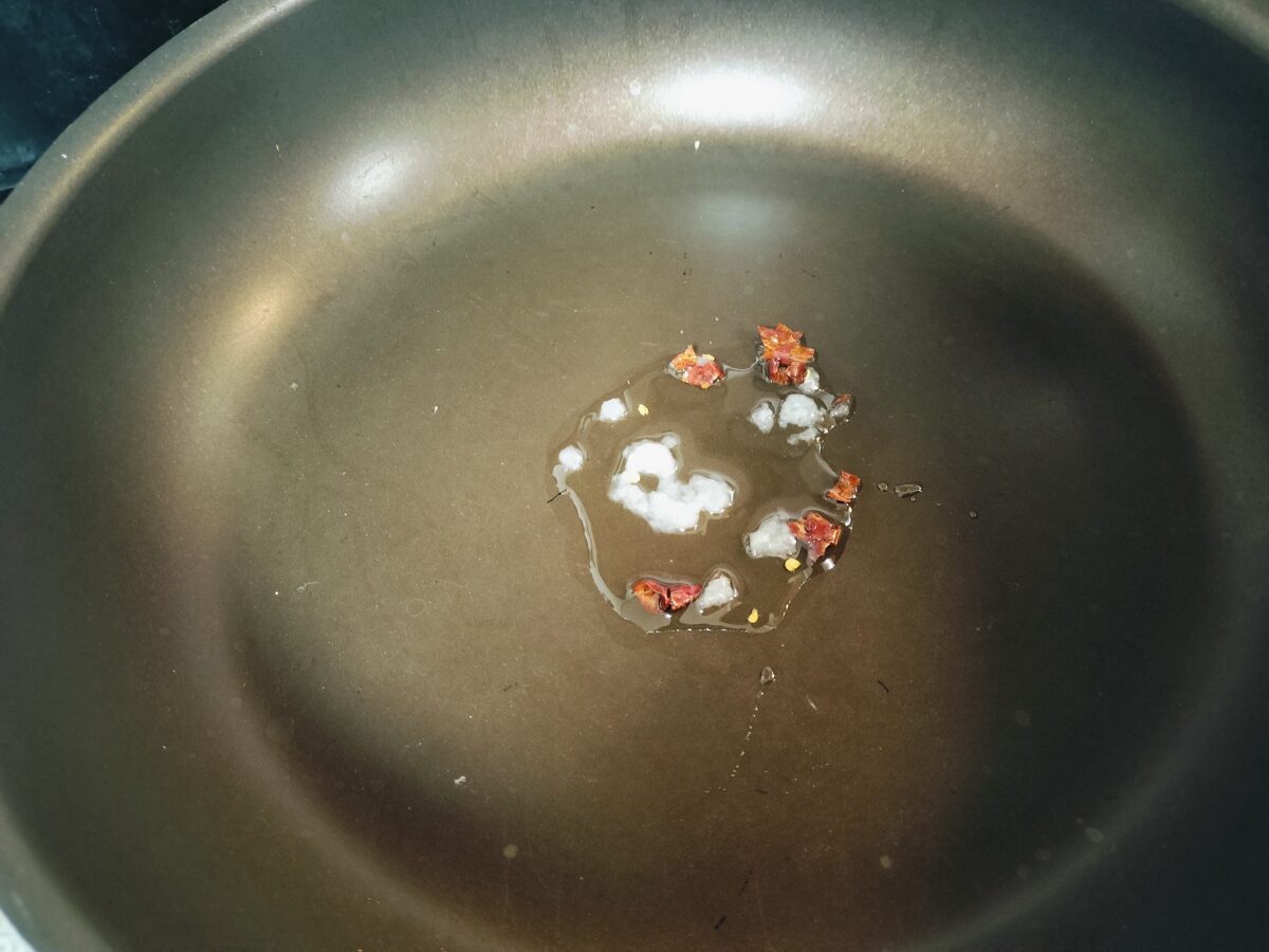 フライパンににんにくと鷹の爪をいれる