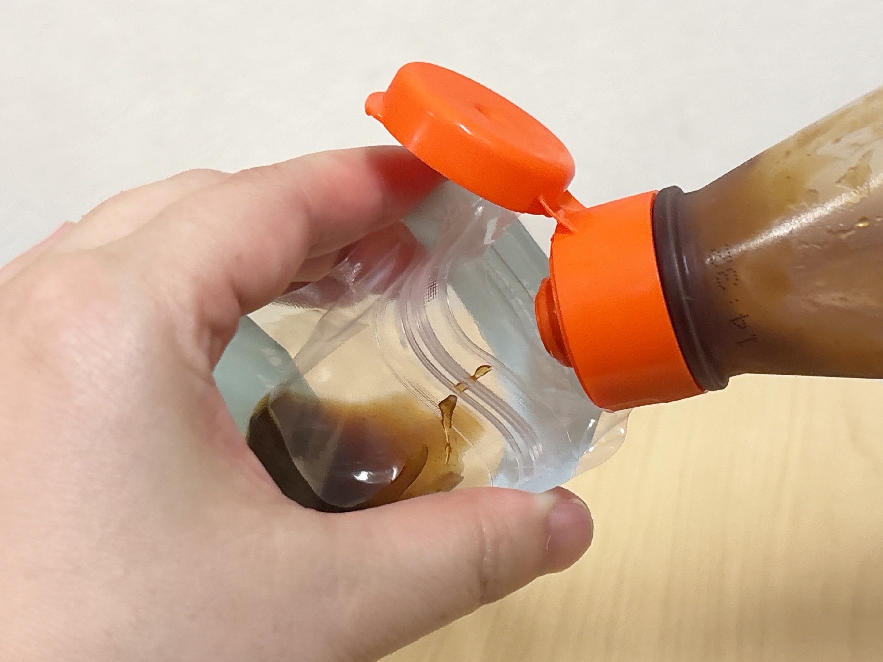 ジッパー式調味料パウチにソースを入れている様子