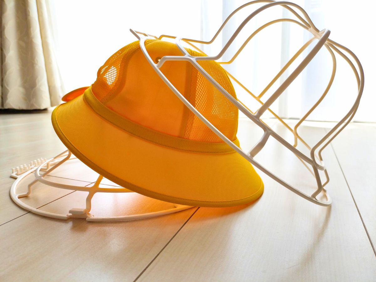 ハットウォッシャーのフレームに通学帽子を挟んでいるところ