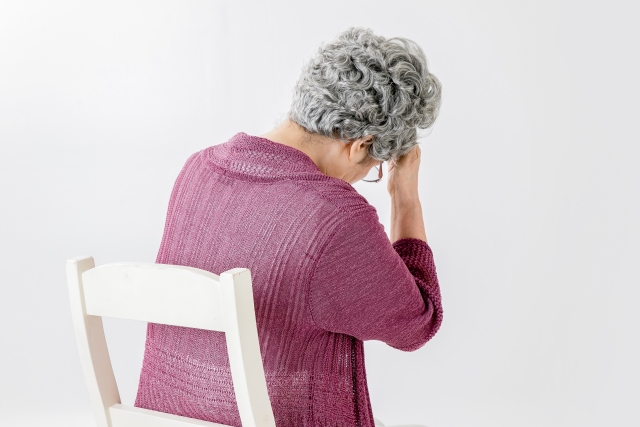 頭を抱える高齢女性