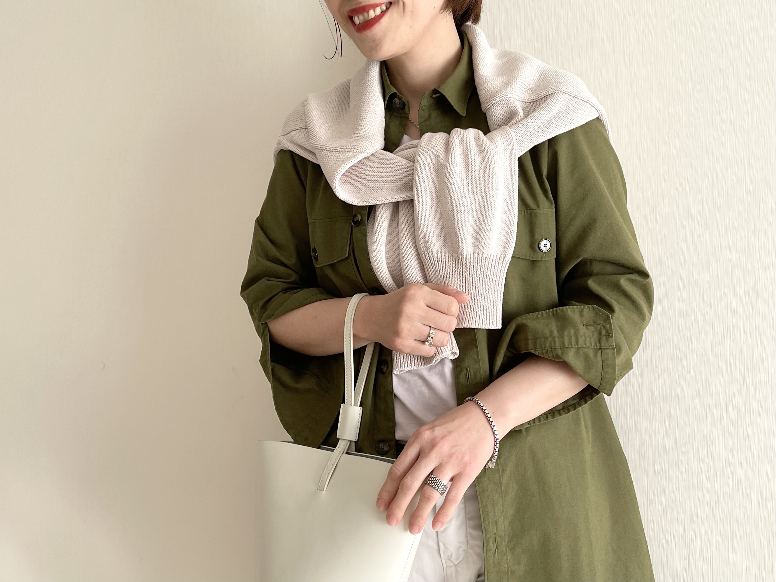 グレーのニットを肩がけ