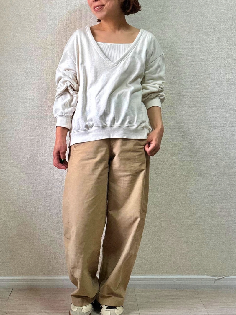 白のVネックスウェットとジャージーバレルレッグパンツを合わせたコーディネート