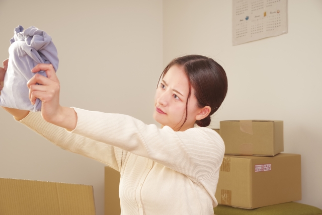 服を持って難しい顔をする女性